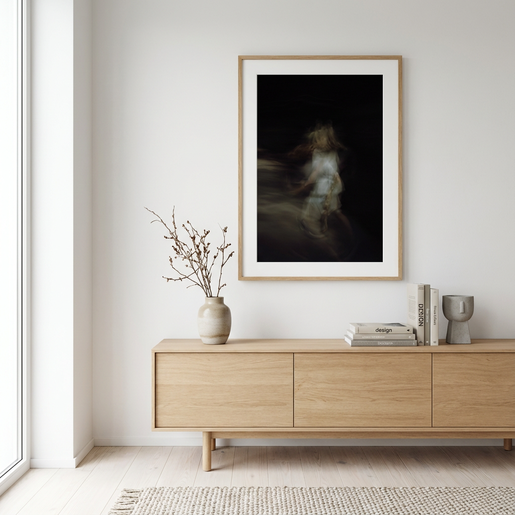 Minimalist stue med lys trebord, vas med tørre kvister, og abstrakt kunstverk på vegg