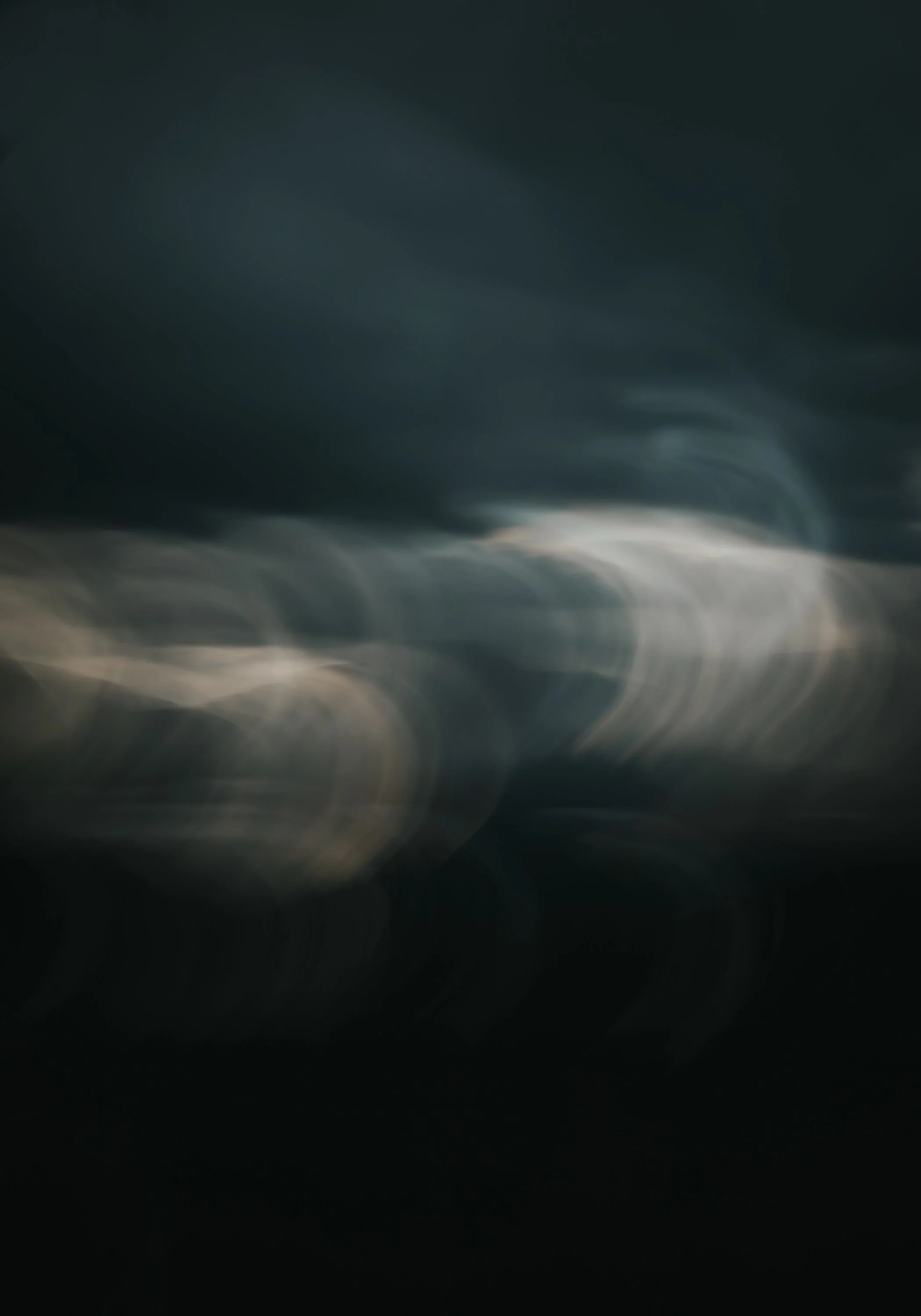 Et mørkt, abstrakt bilde med uskarpe lyspunkter og bølgende mønster.