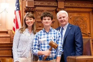 Rep. Anulewicz poses with a House Page holding the Speaker's gavel and Speaker Burns.