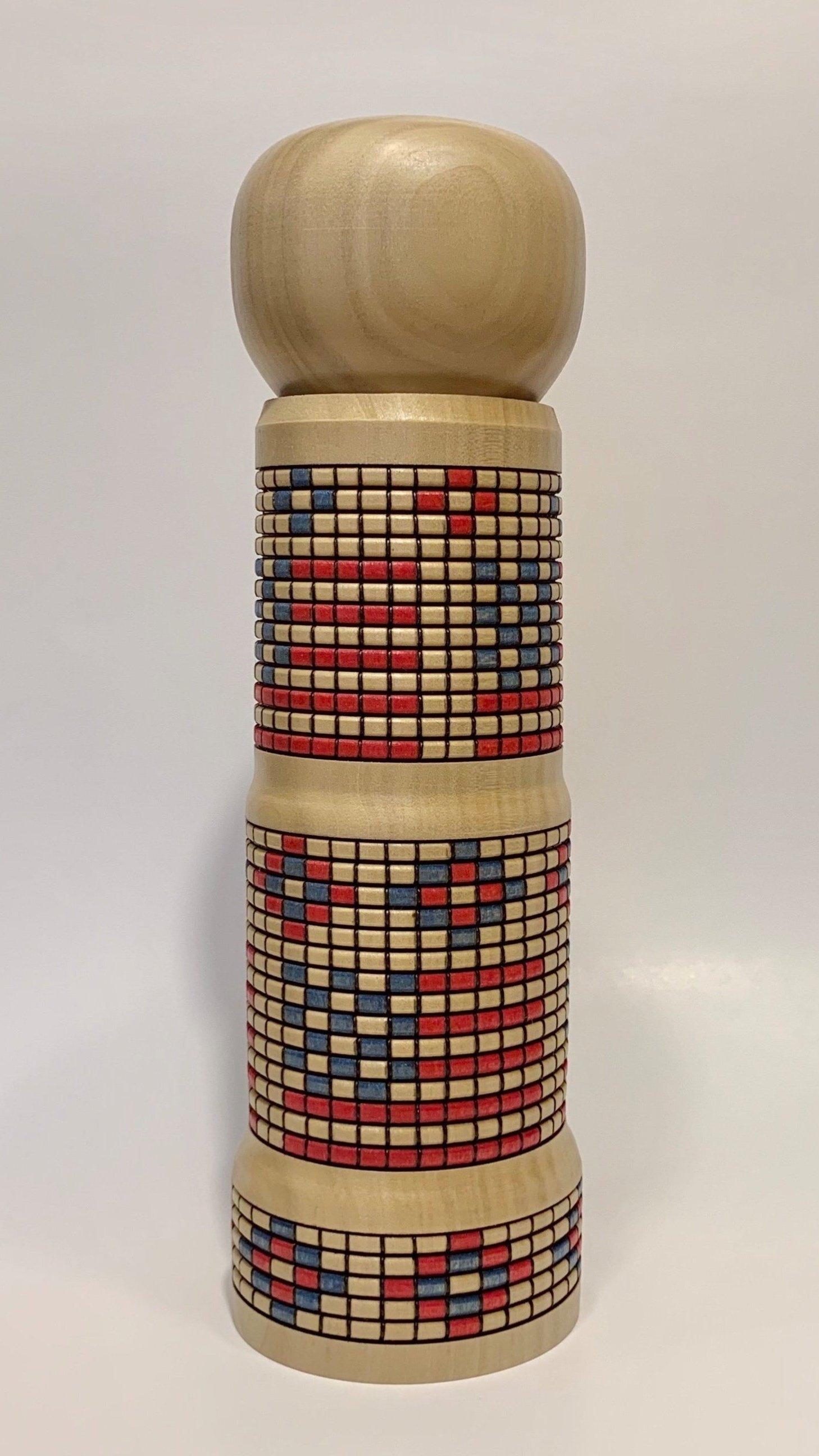 Stack of wooden tiles with red and blue painted patterns on a white background.