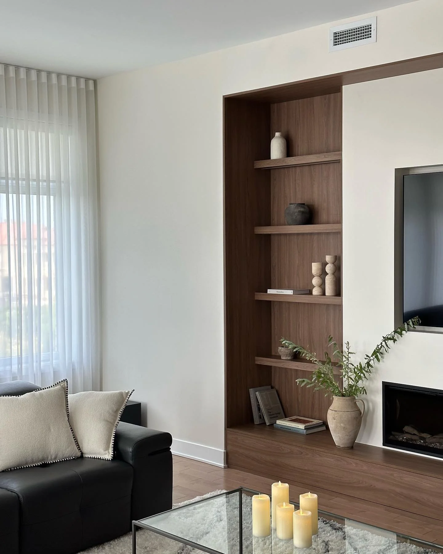 This recessed nook in the living area at our Claude Henri project practically begged for a built-in media unit. 

A harmonious blend of warm wood tones and a soft wall colour brings a welcoming ambiance to the space, all while maintaining the clean, 