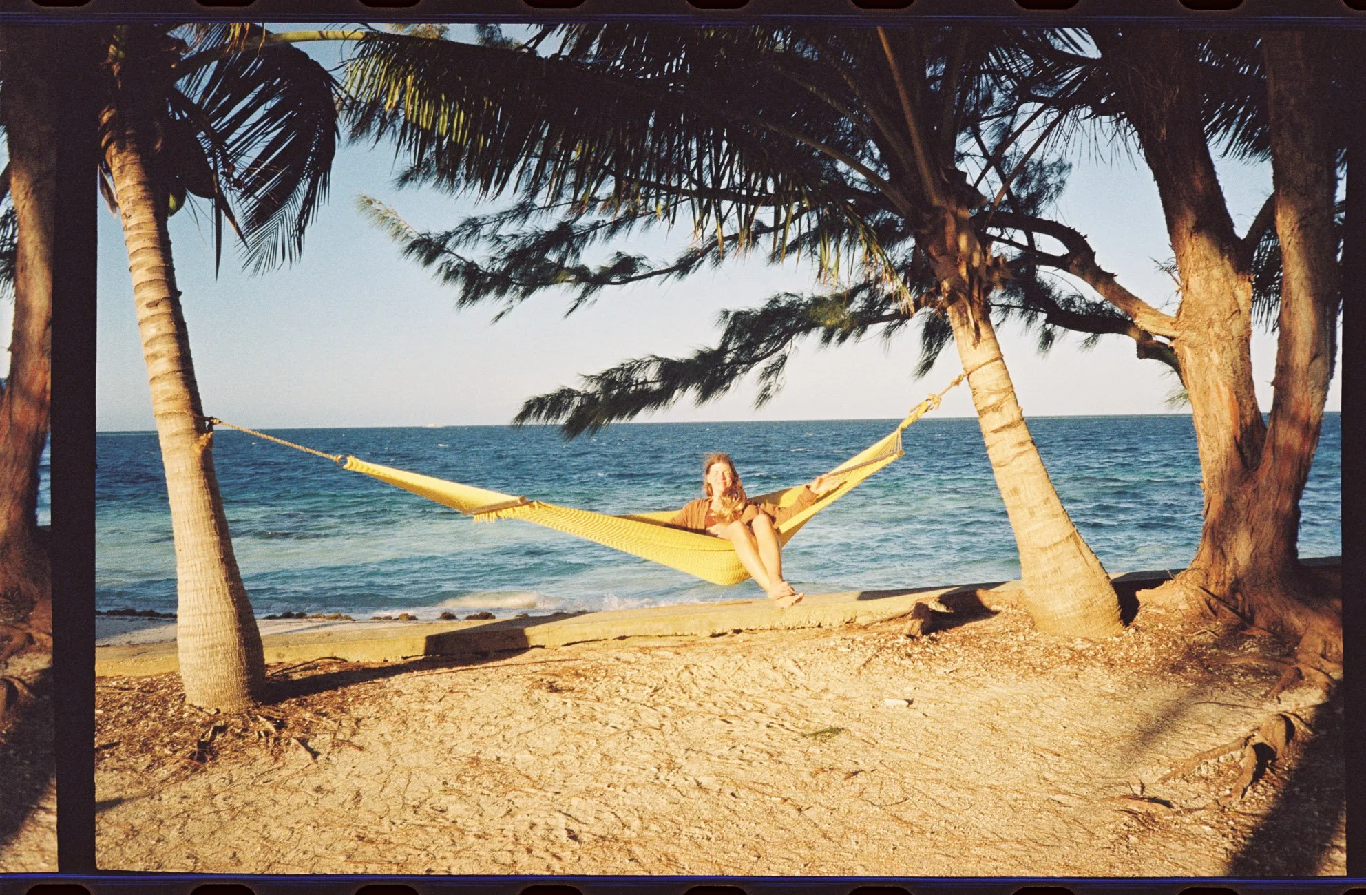 me sitting in a yellow hammock by the ocean