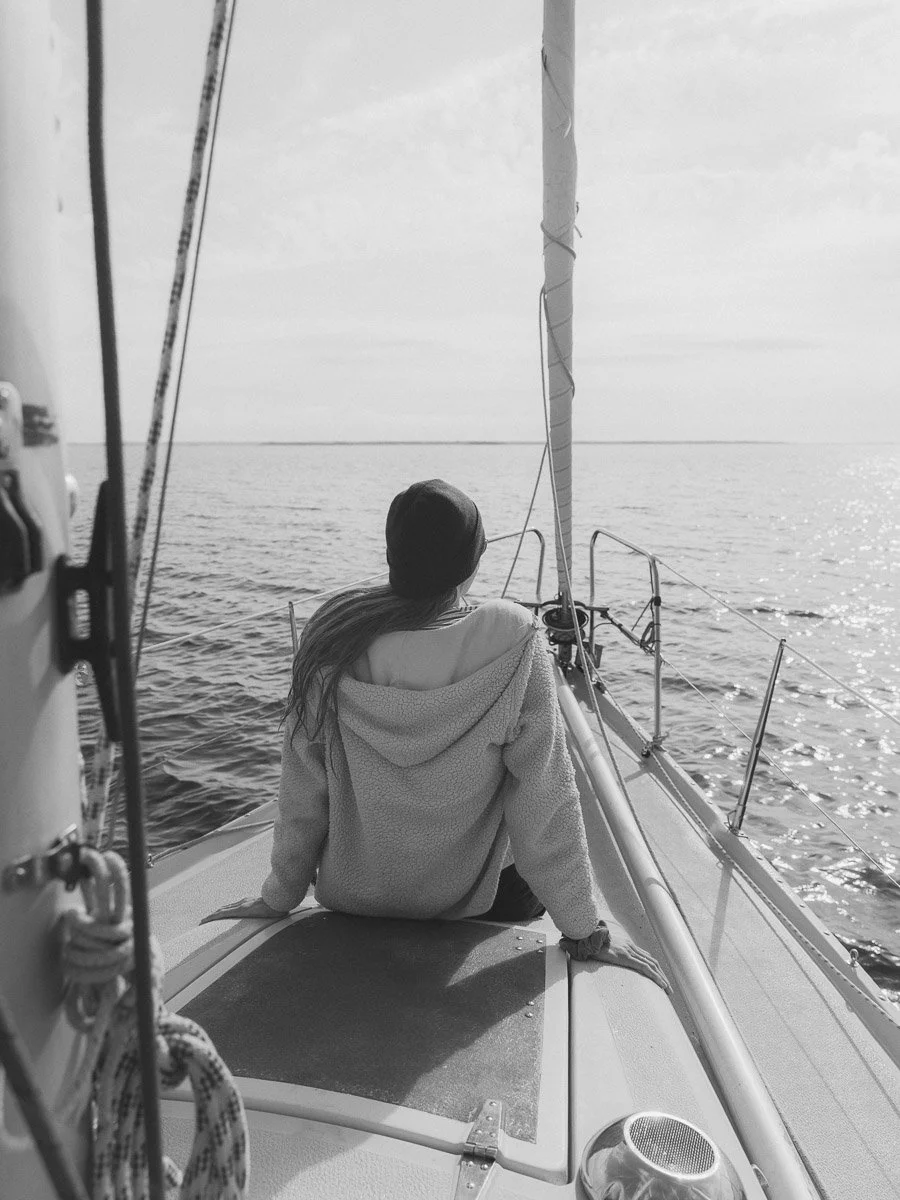 woman sitting at the bow of a sailboat