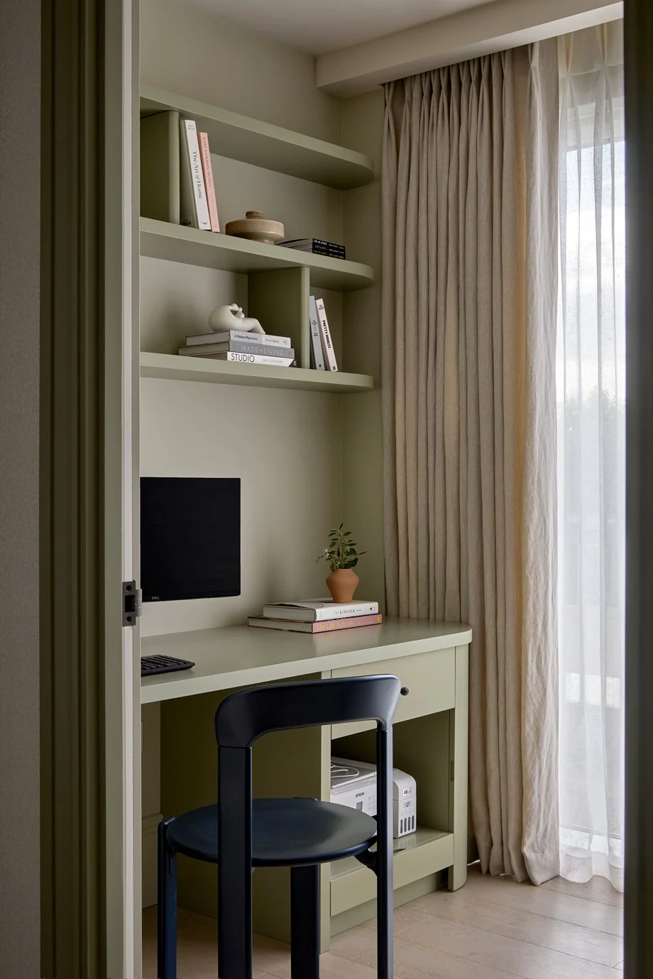 Study with green bespoke joinery incorporating a desk, printer storage and open shelving.