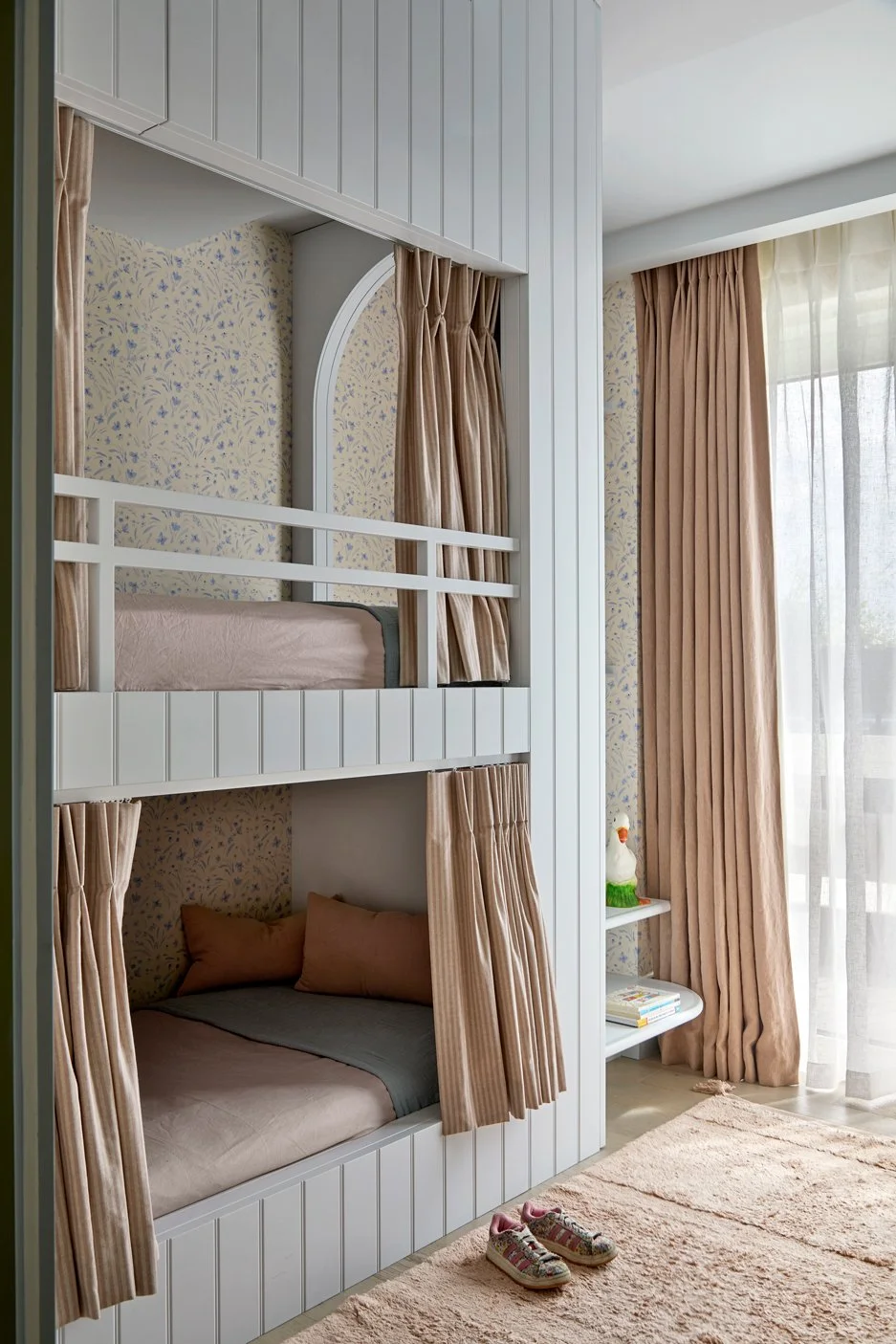 Bespoke bunk bed joinery with integrated stair storage, woven basket and detailed panelling.