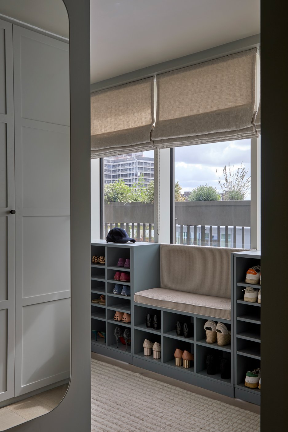 Dressing room with bespoke blue bench seating and integrated shoe storage.
