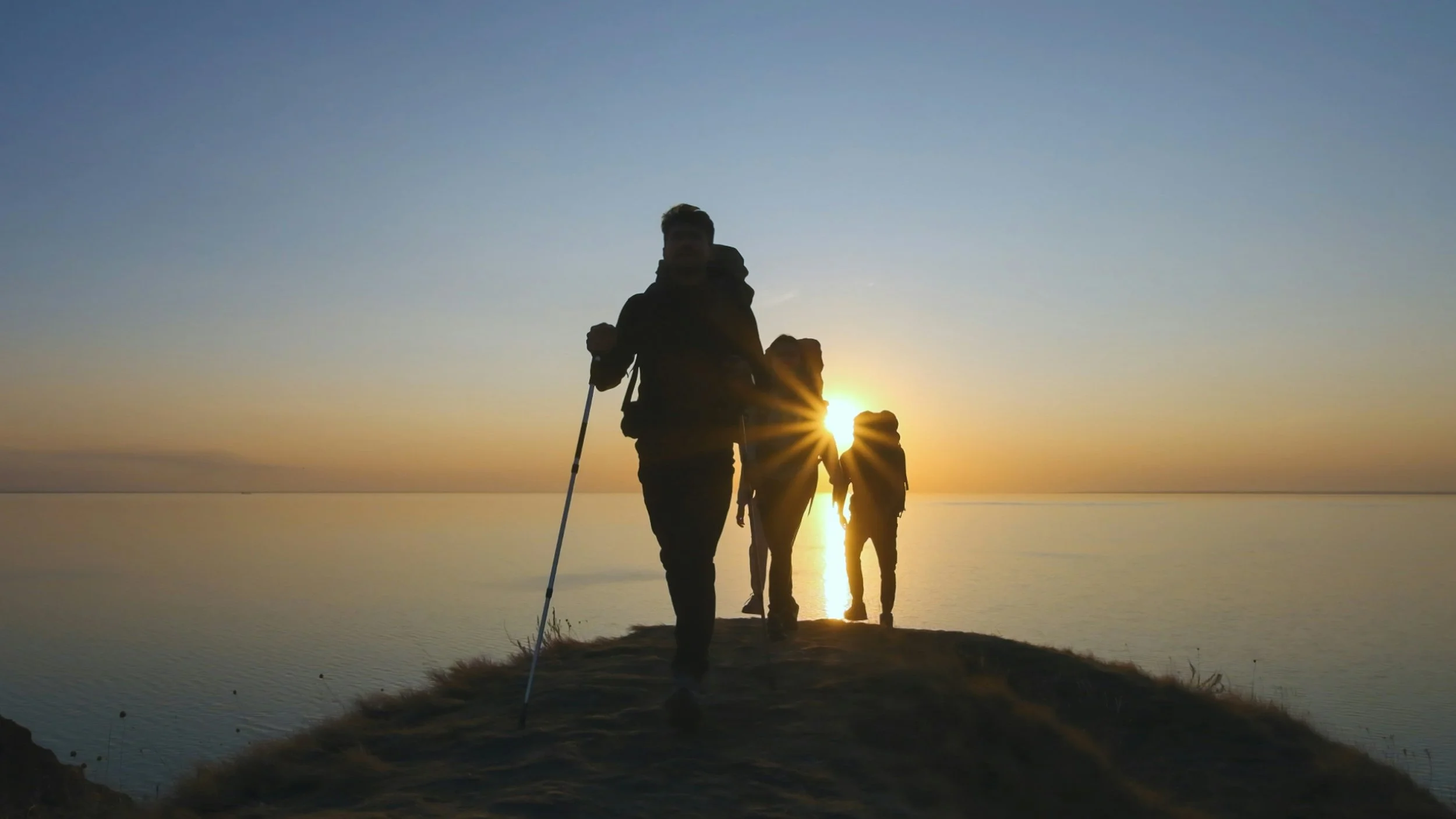 Trail Blazers Hikers cresting mountain at sunset