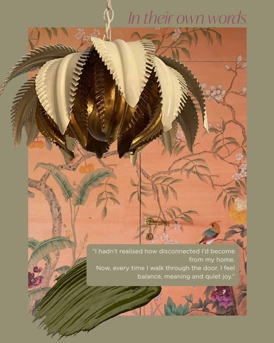 Decorative pendant lamp resembling a flower, with layered petals in gold, white, and dark tones, hanging in front of a pink floral wallpaper background featuring birds and blossoming branches, with a quote about feeling disconnected from home.
