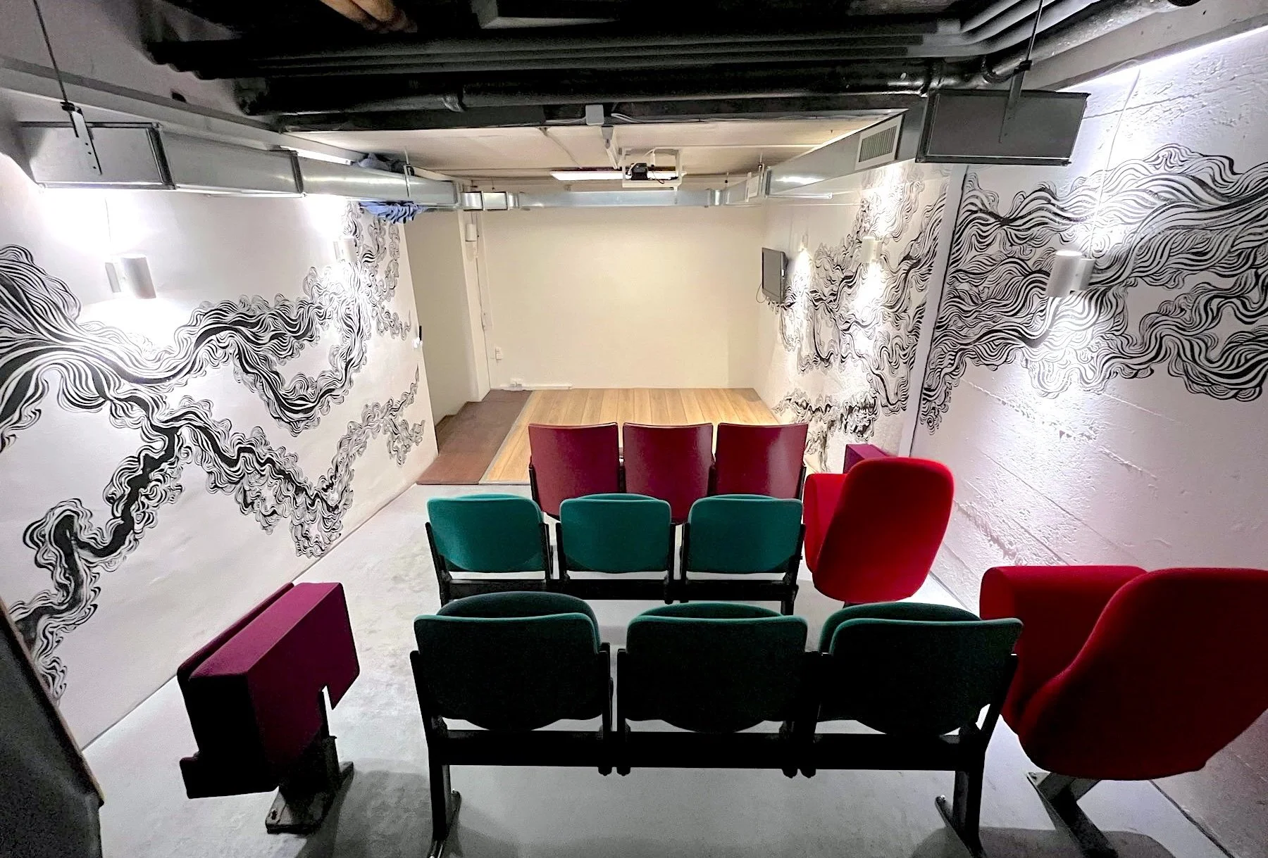 Salle Betty in Geneva, an auditorium with retro movie theater seats and a mural