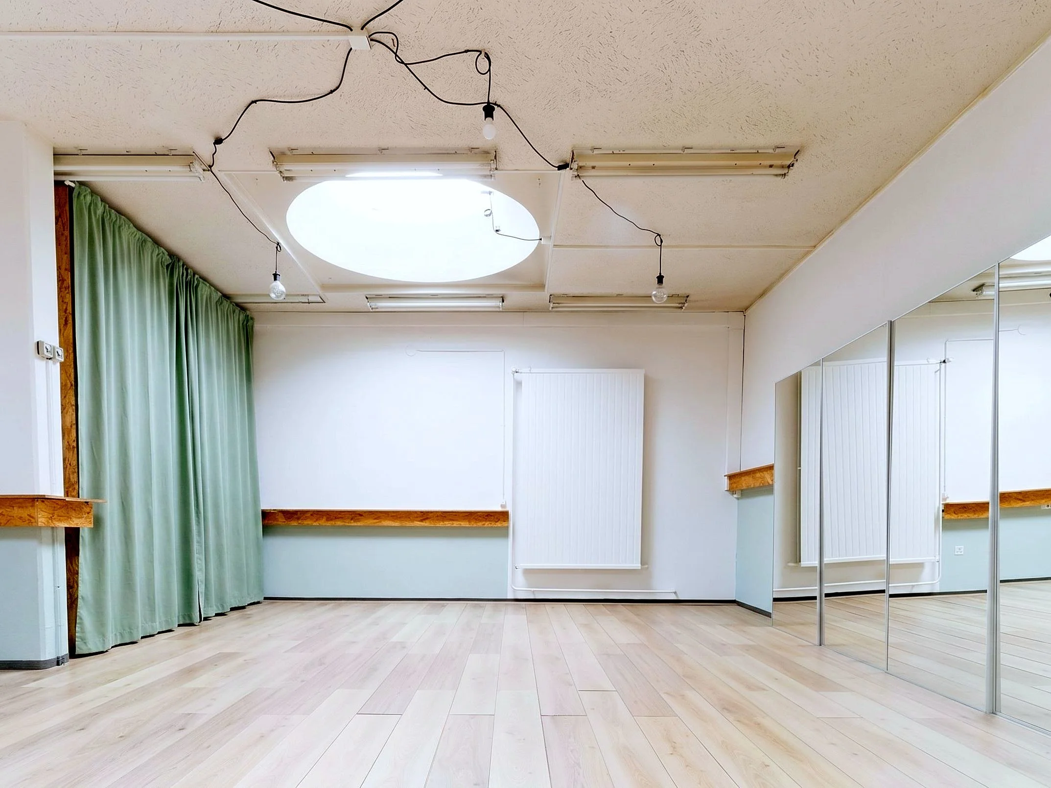 Salle de sport Claudia de 50 m² à louer à Genève : parquet clair, miroirs et barre