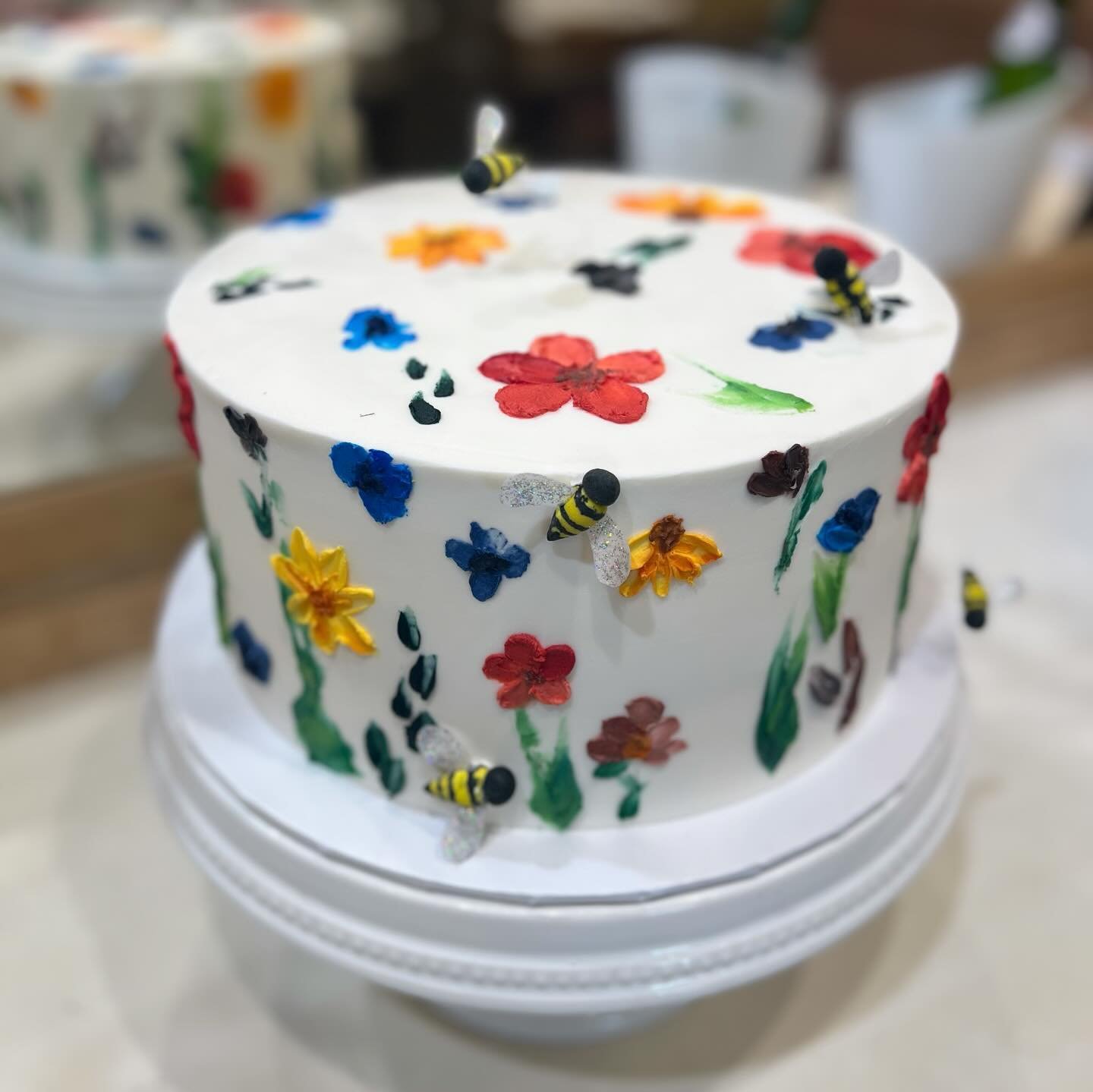 Pretty lil palette knife flowers and &ldquo;buzzing&rdquo; fondant bees on this 10 inch vegan lemon cake 🥹
