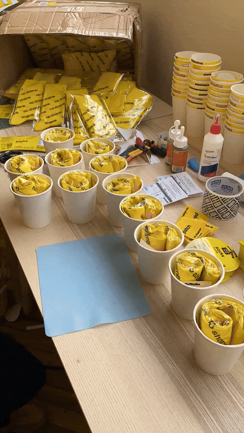 Assembling No Shame socks in a cup packaging. (Copy) (Copy)
