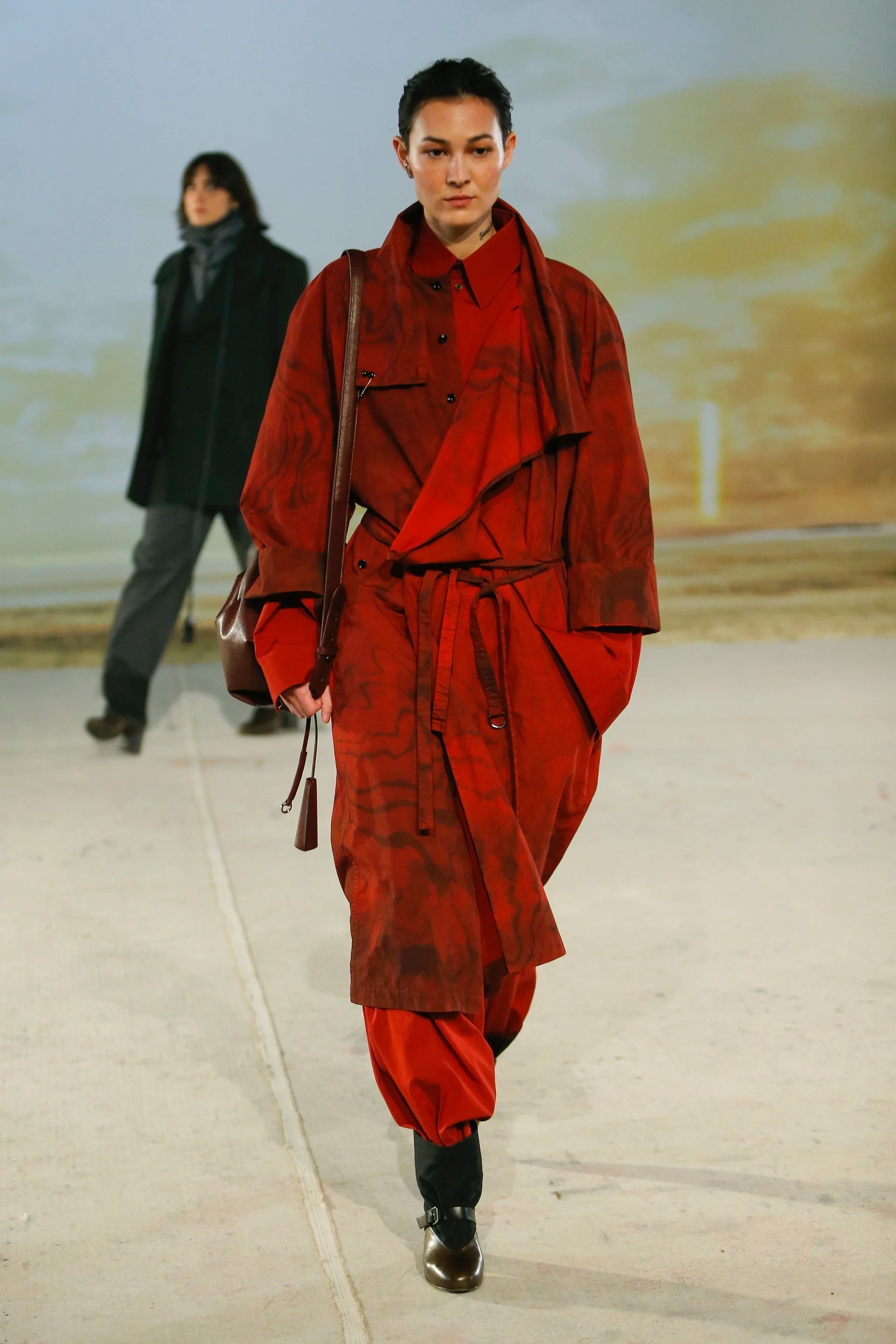 Model on runway for designer Lemaire's FW22  collection dressed in red