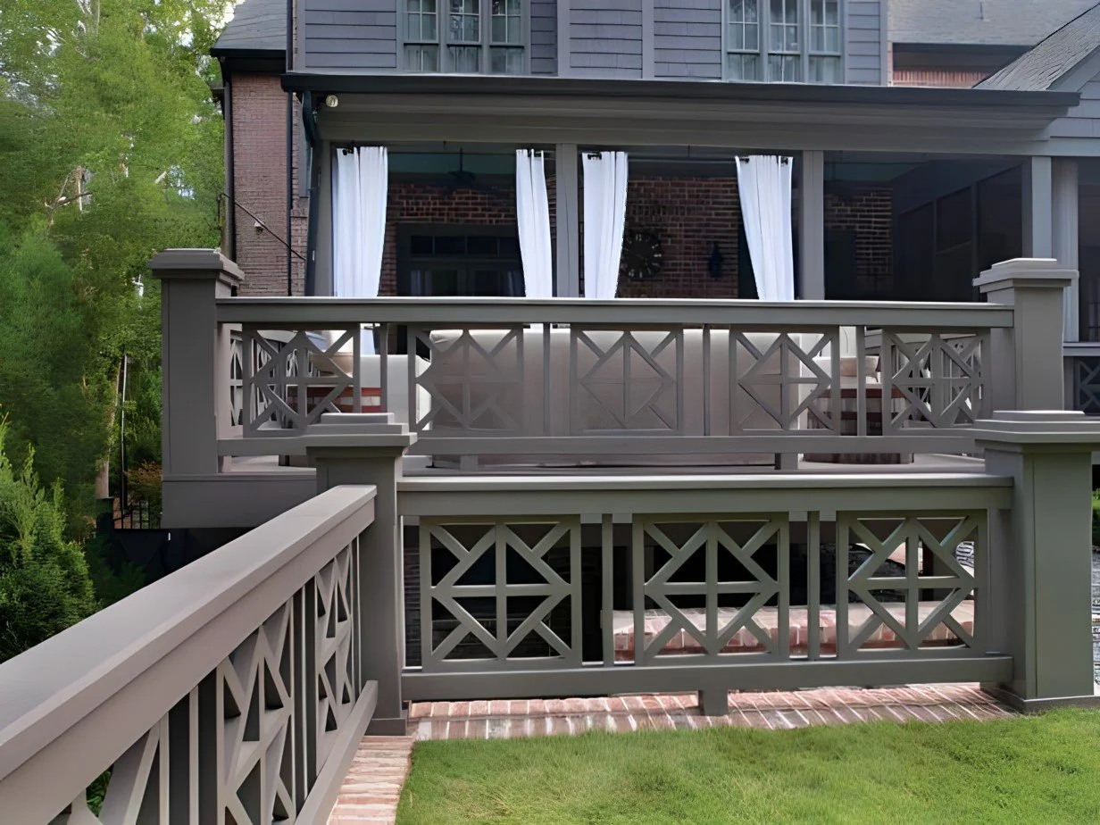 Backyard patio with white curtains and lattice railing on a raised deck attached to a house.