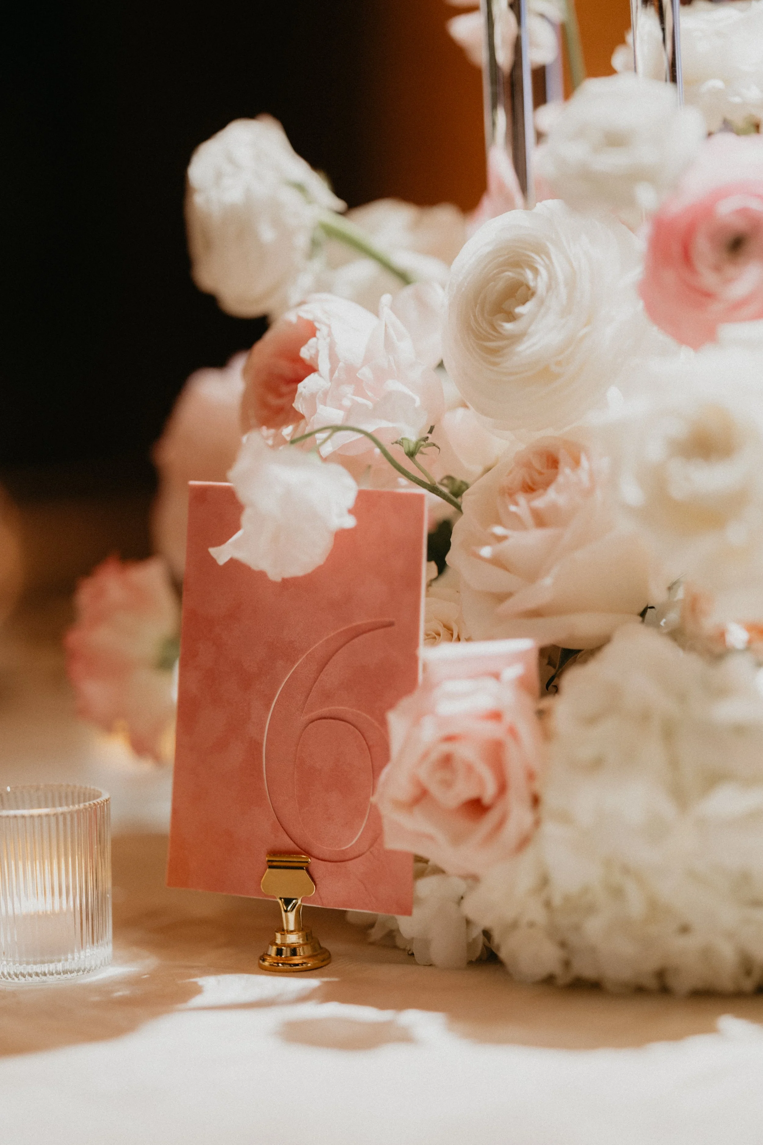 Close-up of a decorative wedding place card with the word 'Bride,' tied with beige ribbon and a dried orange slice.