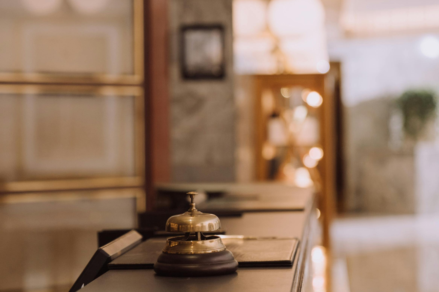 Close-up of a hotel reception bell on a counter with blurred background.