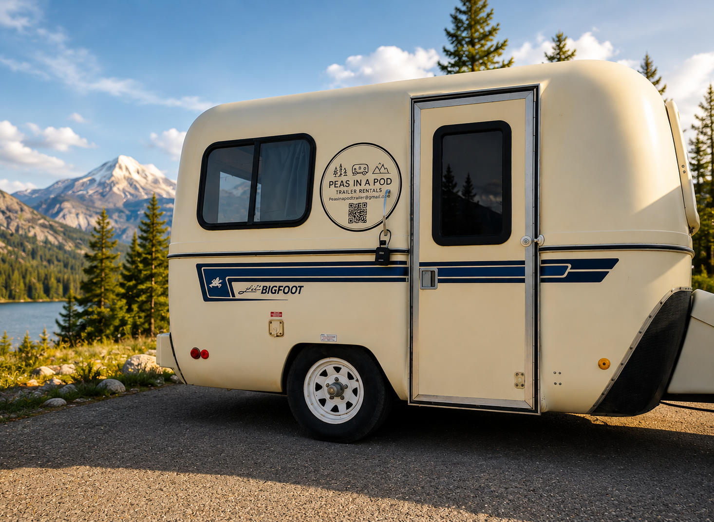 A beige travel trailer parked on a paved road with mountainous landscape and pine trees in the background. Advertising says "Peas in a Pod Trailer Rentals."