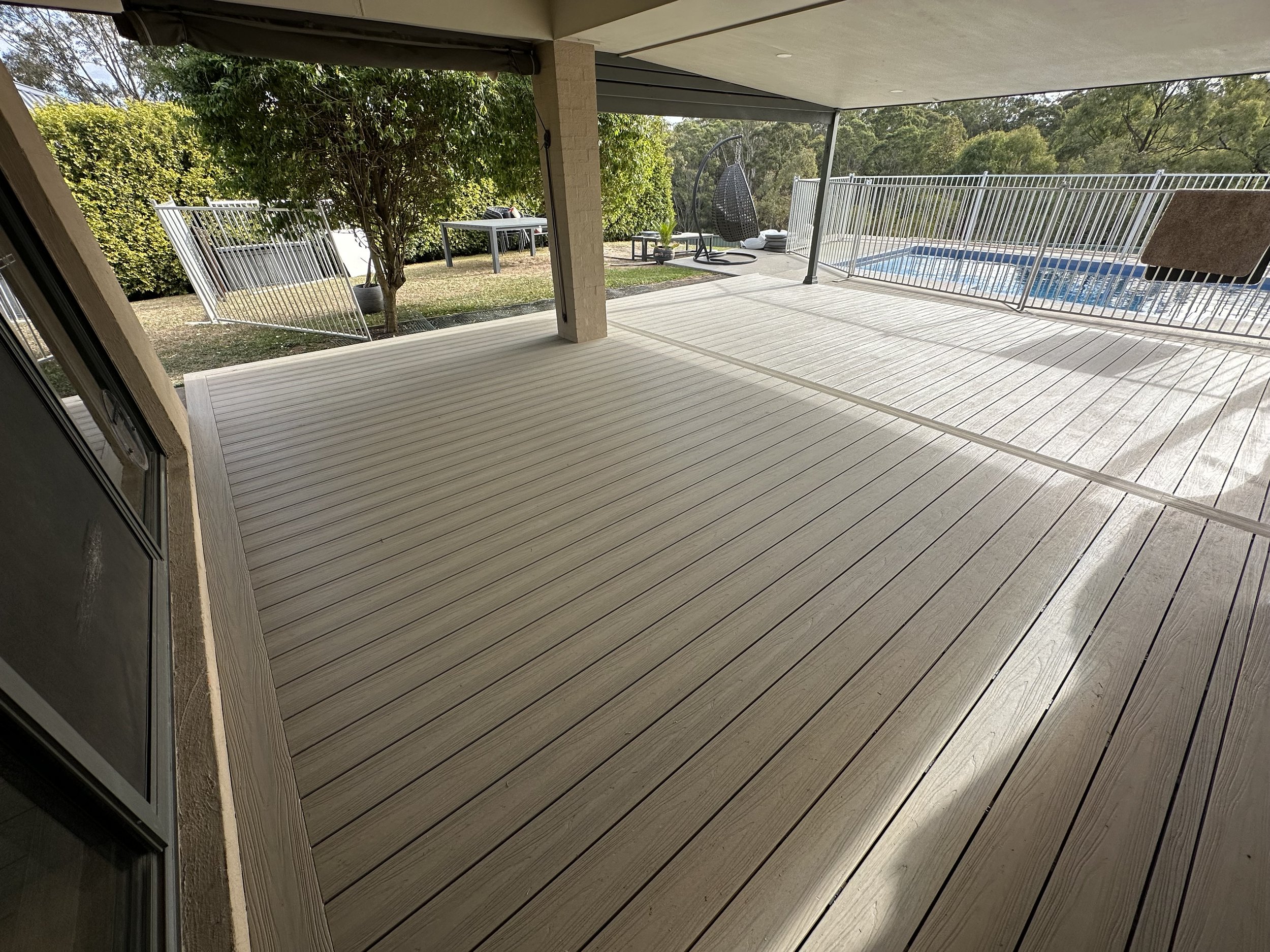 Composite deck installed for a seamless transition into pool yard. We worked with the pool company to ensure drainage was fully functional.