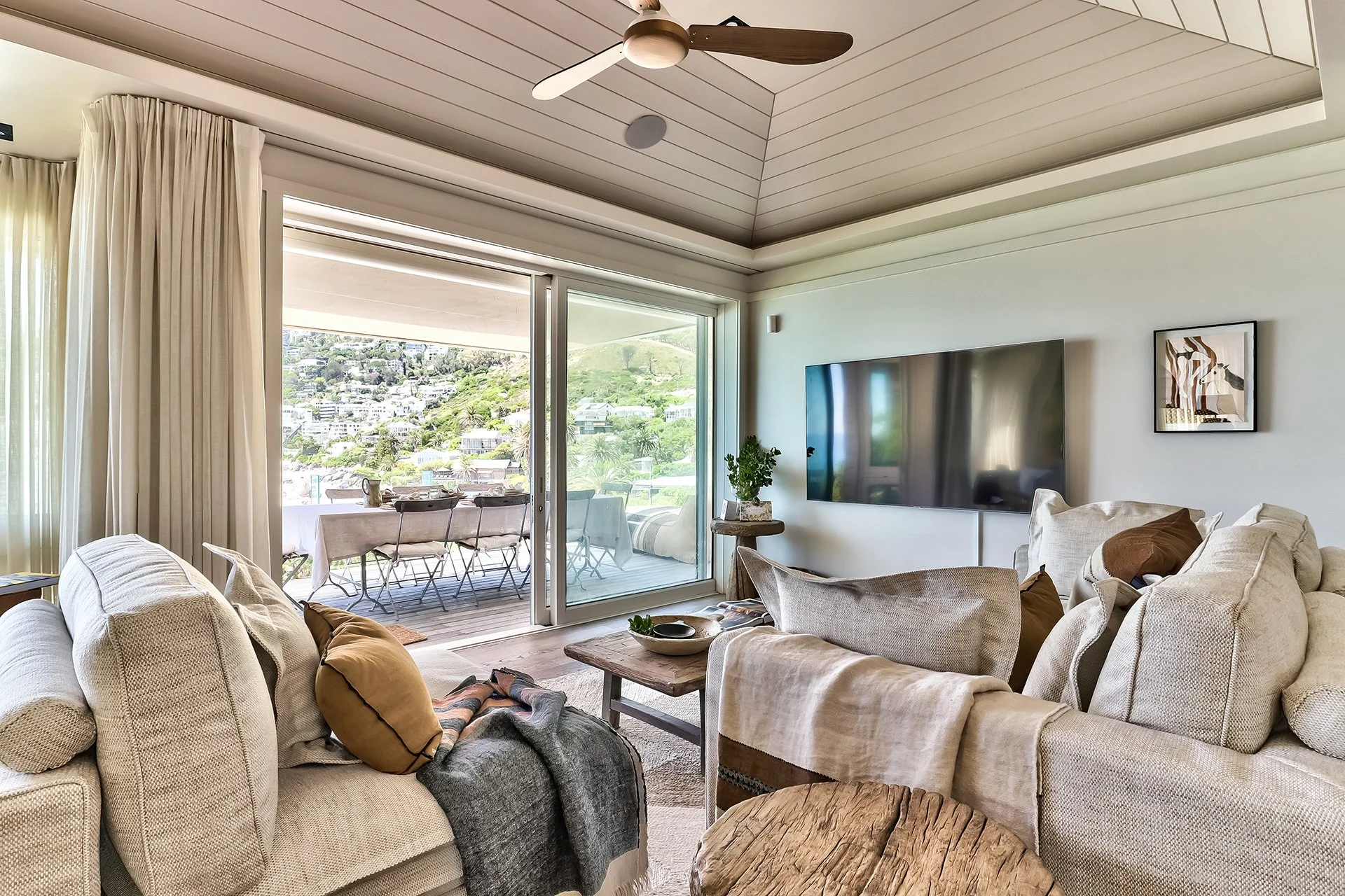 Open-plan space fusing kitchen, dining and living areas with dreamy views and access to beachfront deck through floor-to-ceiling windows. In the living room and dining area there’s a magnificent artisan wood dining table with space for eight guests, 