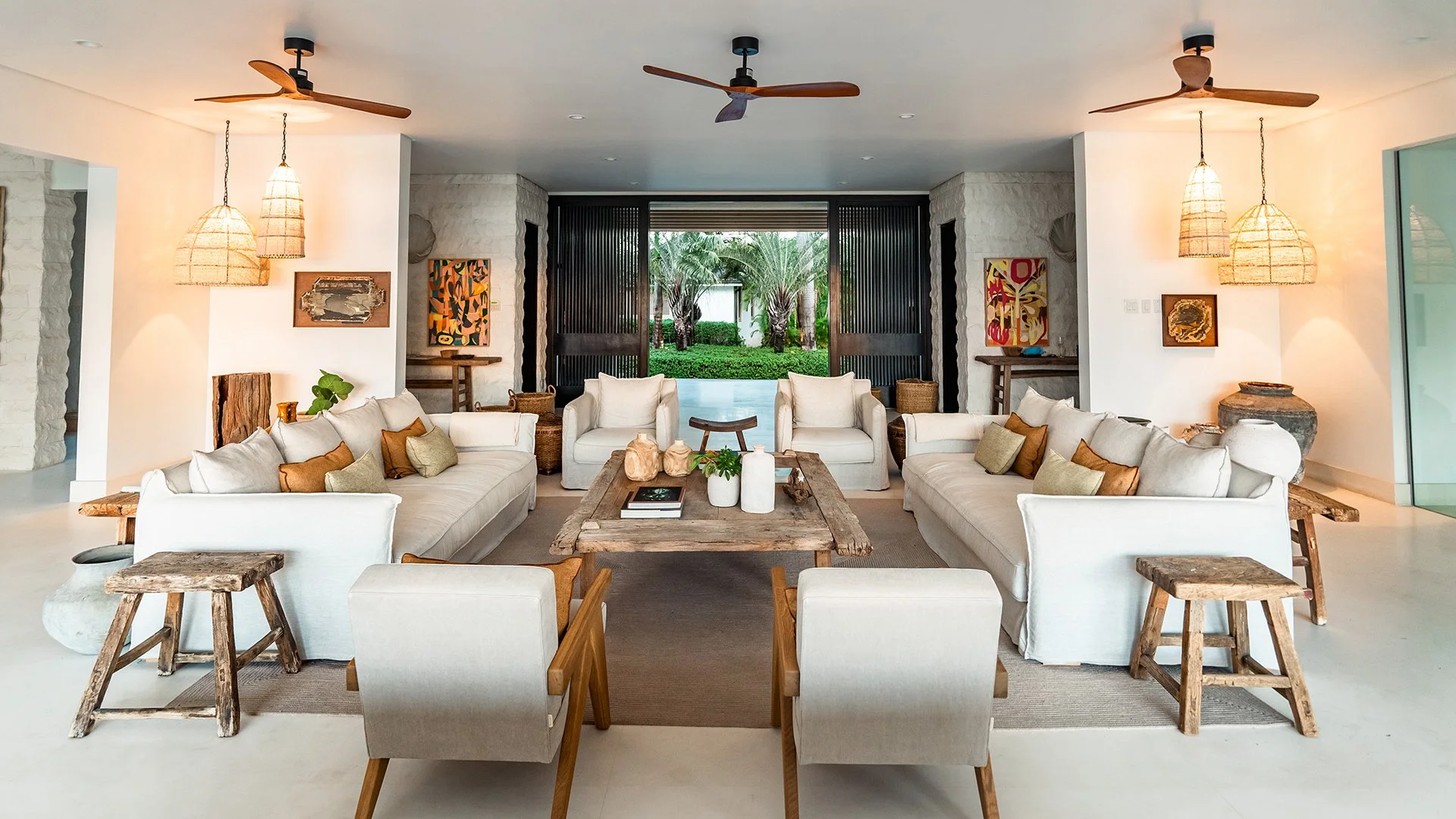 The spacious open plan living area has calming neutral tones, pale limestone flooring and an impressive local coral feature wall. Large windows emphasise the surrounding sea and pool views. Discover more about Godings, Barbados. 