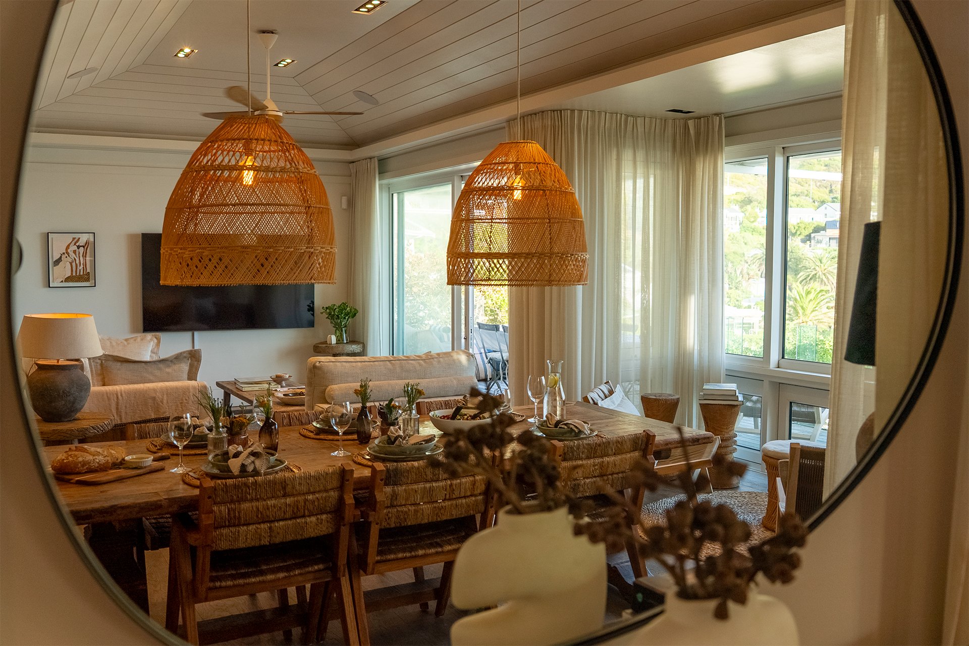 Open-plan space fusing kitchen, dining and living areas with dreamy views and access to beachfront deck through floor-to-ceiling windows. In the living room and dining area there’s a magnificent artisan wood dining table with space for eight guests, 