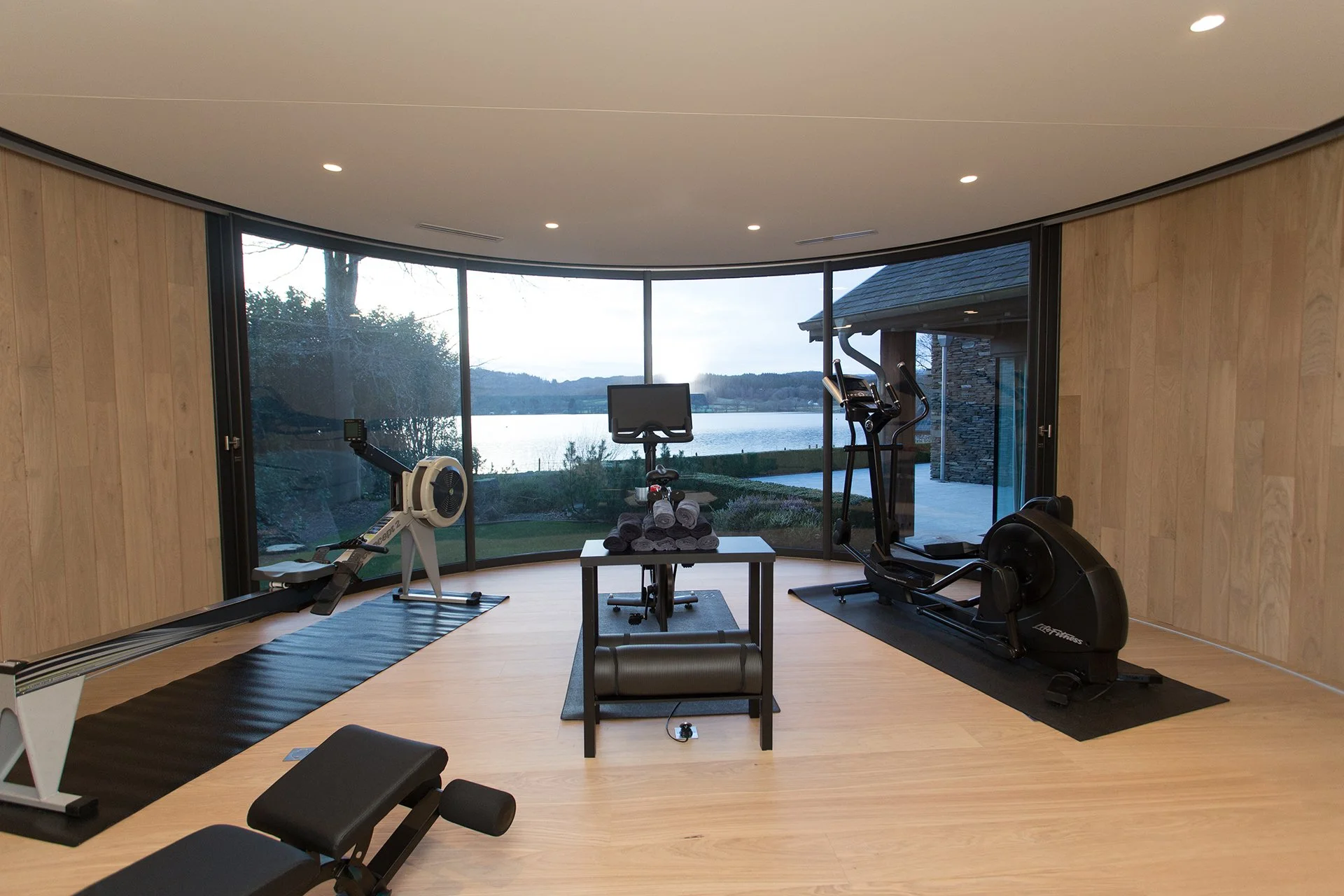 A private lumipod gym, equipped with Peloton bike, cross trainer, rower and free weights with Lake views, provides a serene space for fitness and relaxation.