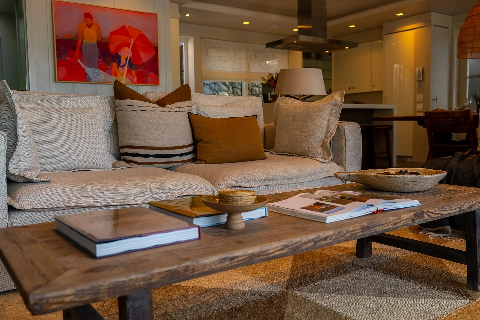 Open-plan space fusing kitchen, dining and living areas with dreamy views and access to beachfront deck through floor-to-ceiling windows. In the living room and dining area there’s a magnificent artisan wood dining table with space for eight guests. 