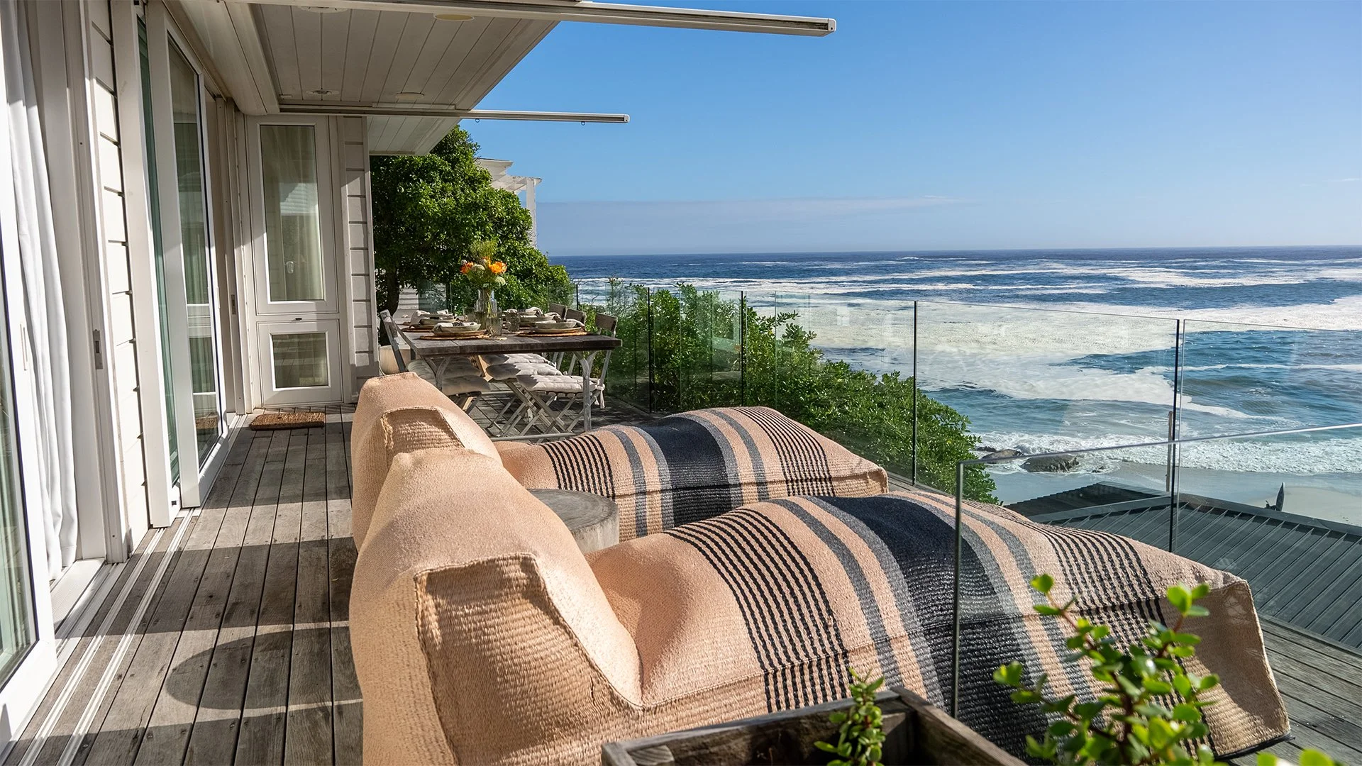 The three bedrooms, each with en suite bathroom, sleep up to six guests and all have access to the outside. The open-plan kitchen, dining, living area and floor-to-ceiling windows open onto a spectacular glass-walled deck with gorgeous views. 