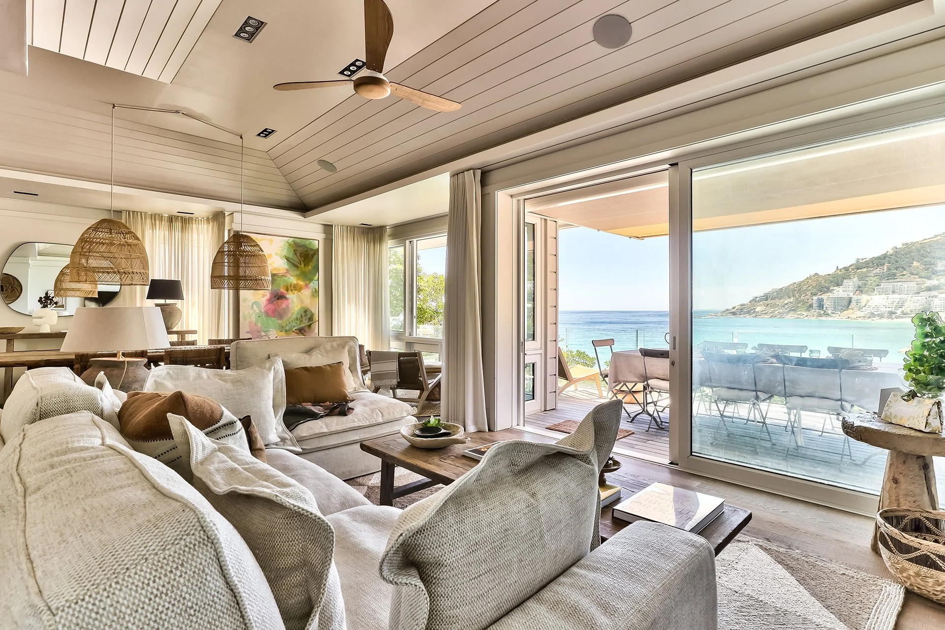 Open-plan space fusing kitchen, dining and living areas with dreamy views and access to beachfront deck through floor-to-ceiling windows. In the living room and dining area there’s a magnificent artisan wood dining table with space for eight guests, 