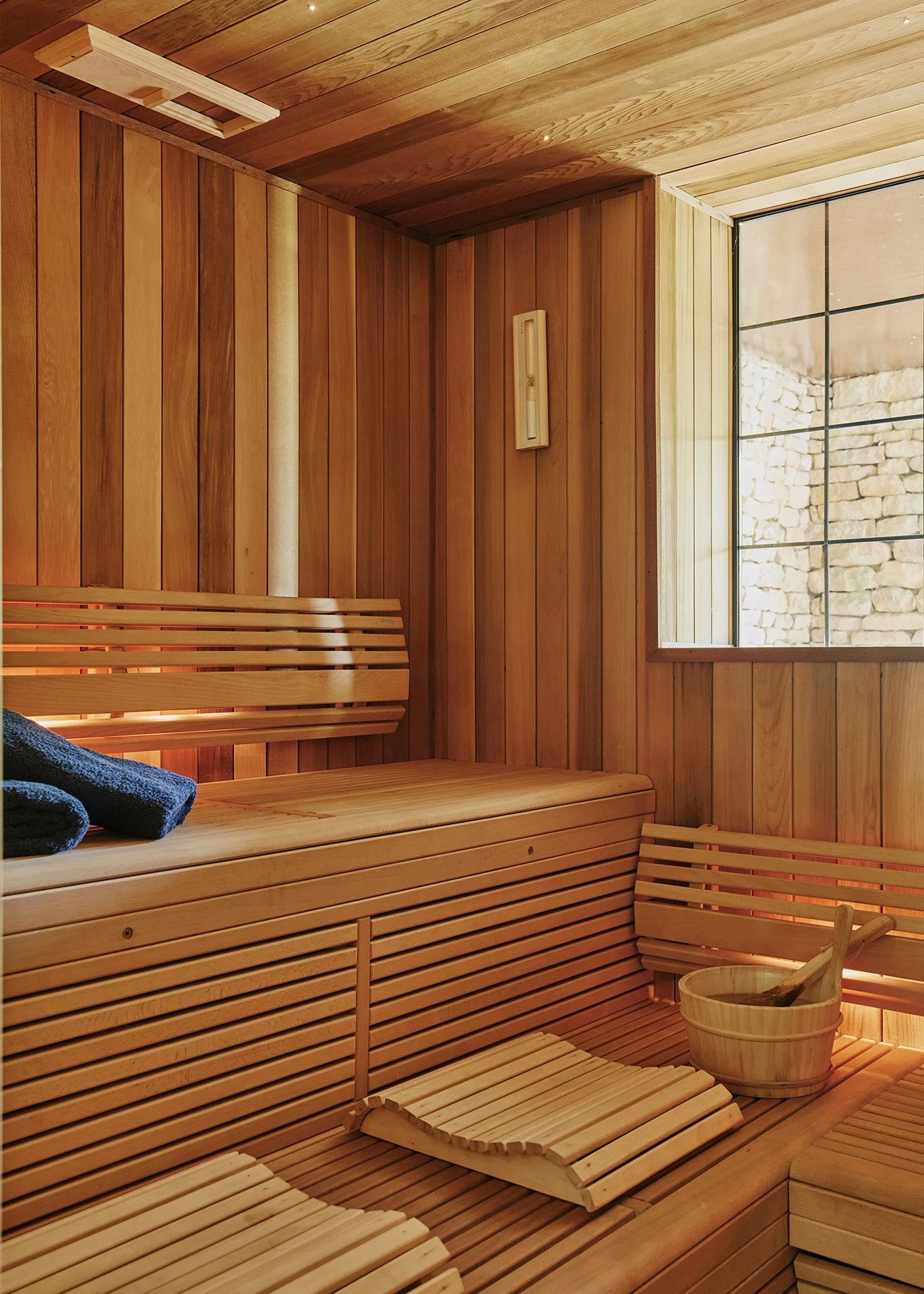  A large cedar sauna has beech seating with rainbow LED lighting and an adjacent cloakroom with marble mosaic tiling and drench shower.