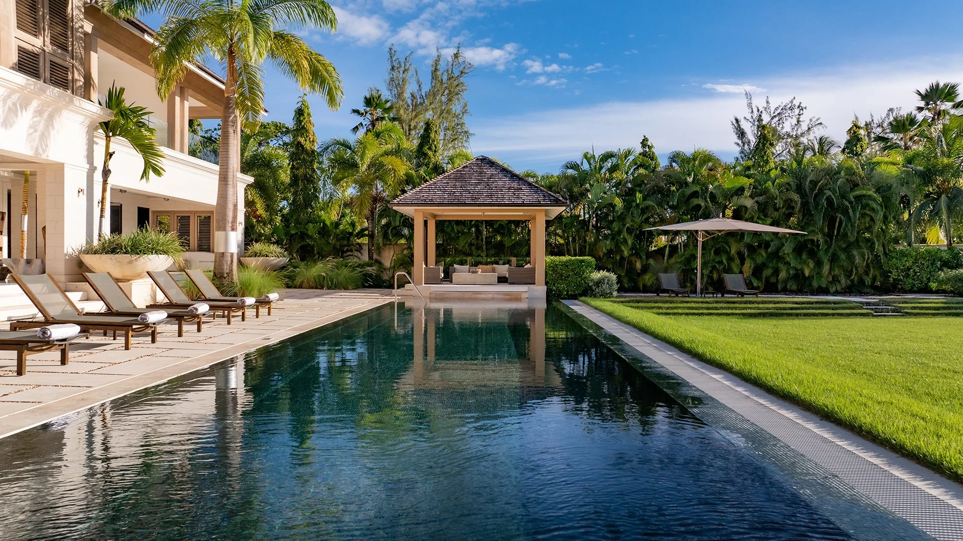The sleek 25m mosaic-lined pool surrounded by limestone tiles and comfy sun loungers. Around 1.2 acres of landscaped gardens with palm trees, scented shrubs and a spice garden. The ultimate beachfront property located in St Peter, Barbados. 