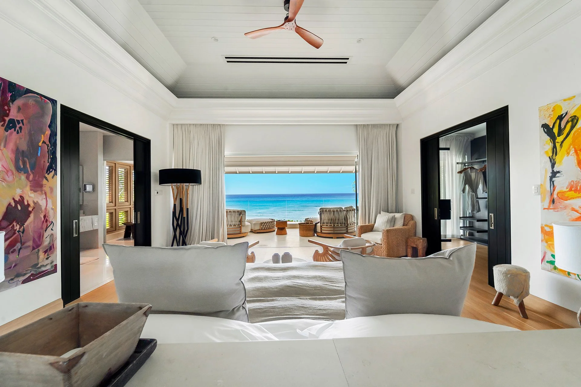 A double staircase with feature Verpan seashell chandelier leads upstairs to five spacious en suite bedrooms, some with four-poster beds; all with American oak flooring, Ralph Lauren bed stools and other unique design pieces.