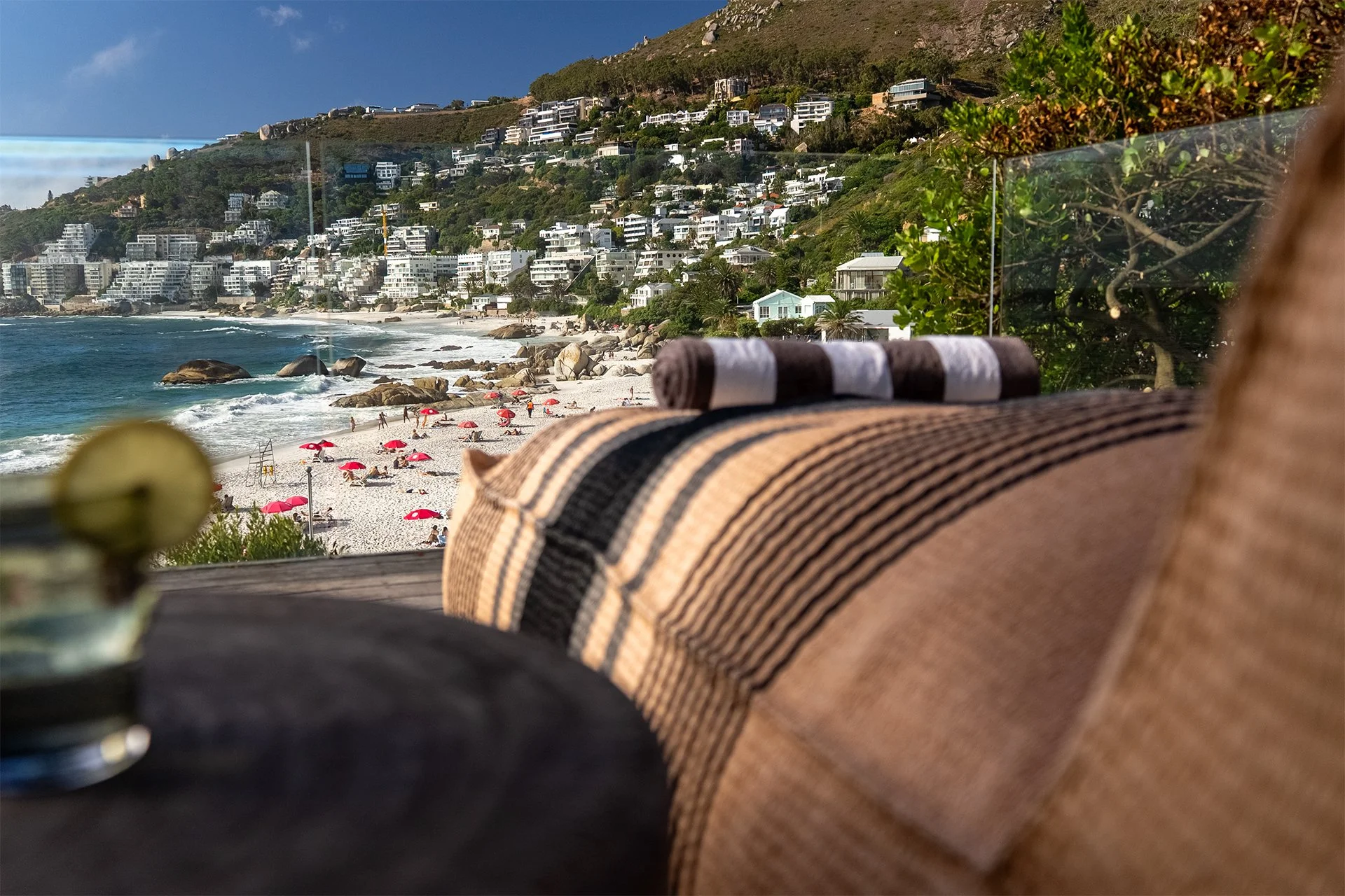 Long glass-walled beachfront deck with sunbeds and outdoor dining table for eight guests with braai / BBQ area behind the kitchen. Direct access to beach down 40 steps.