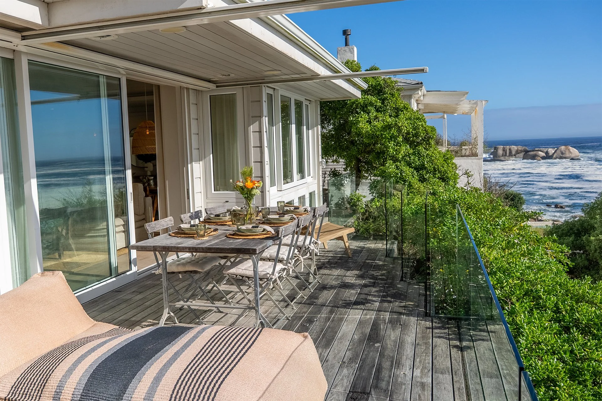 The open-plan kitchen, dining, living area and floor-to-ceiling windows open onto a spectacular glass-walled deck with gorgeous views. 