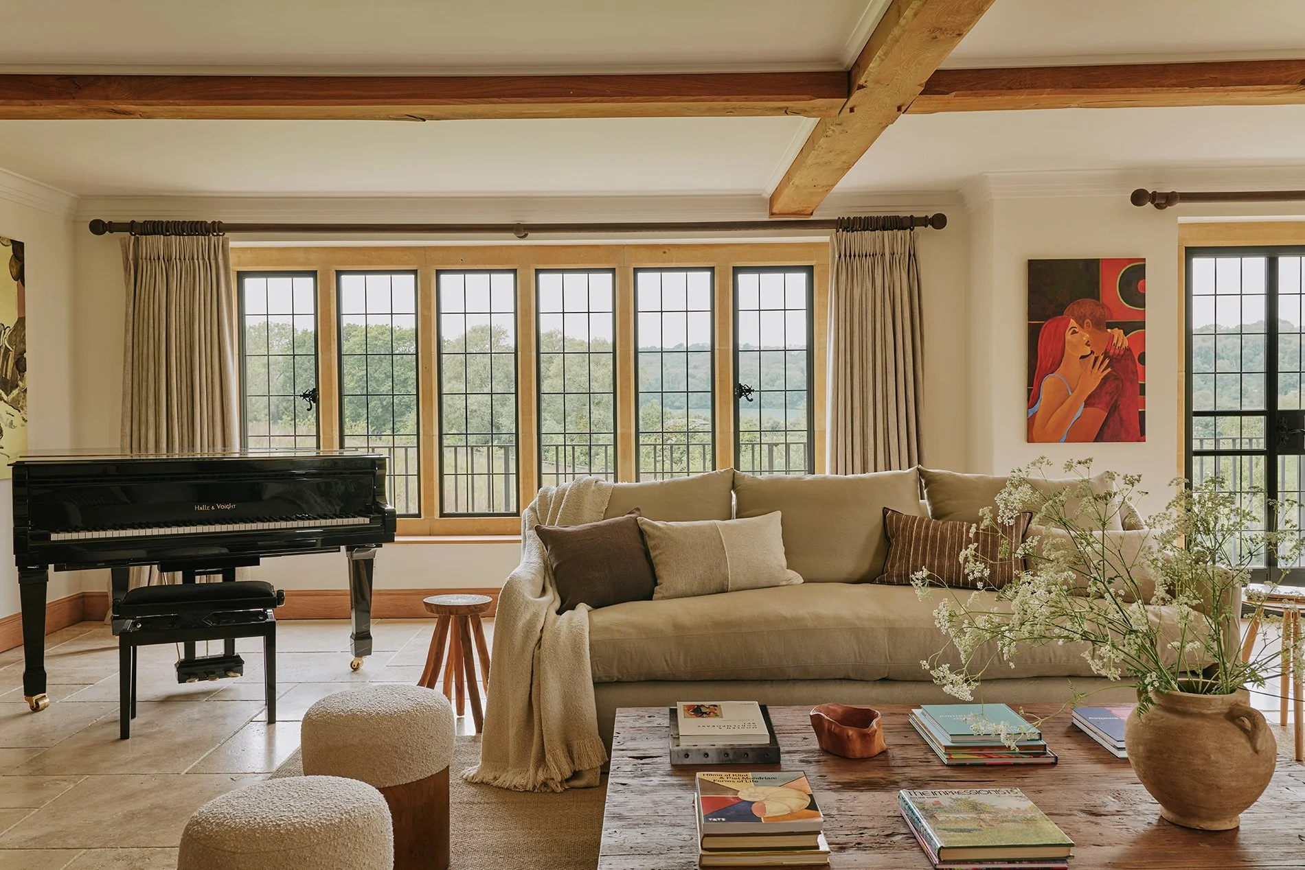 A stylish and elegant living area, with a large woodburning stove, flagstone flooring, decadent rugs and two sumptuous sofas. There’s also a baby grand piano - arrangements can be made for a local pianist to play for you.