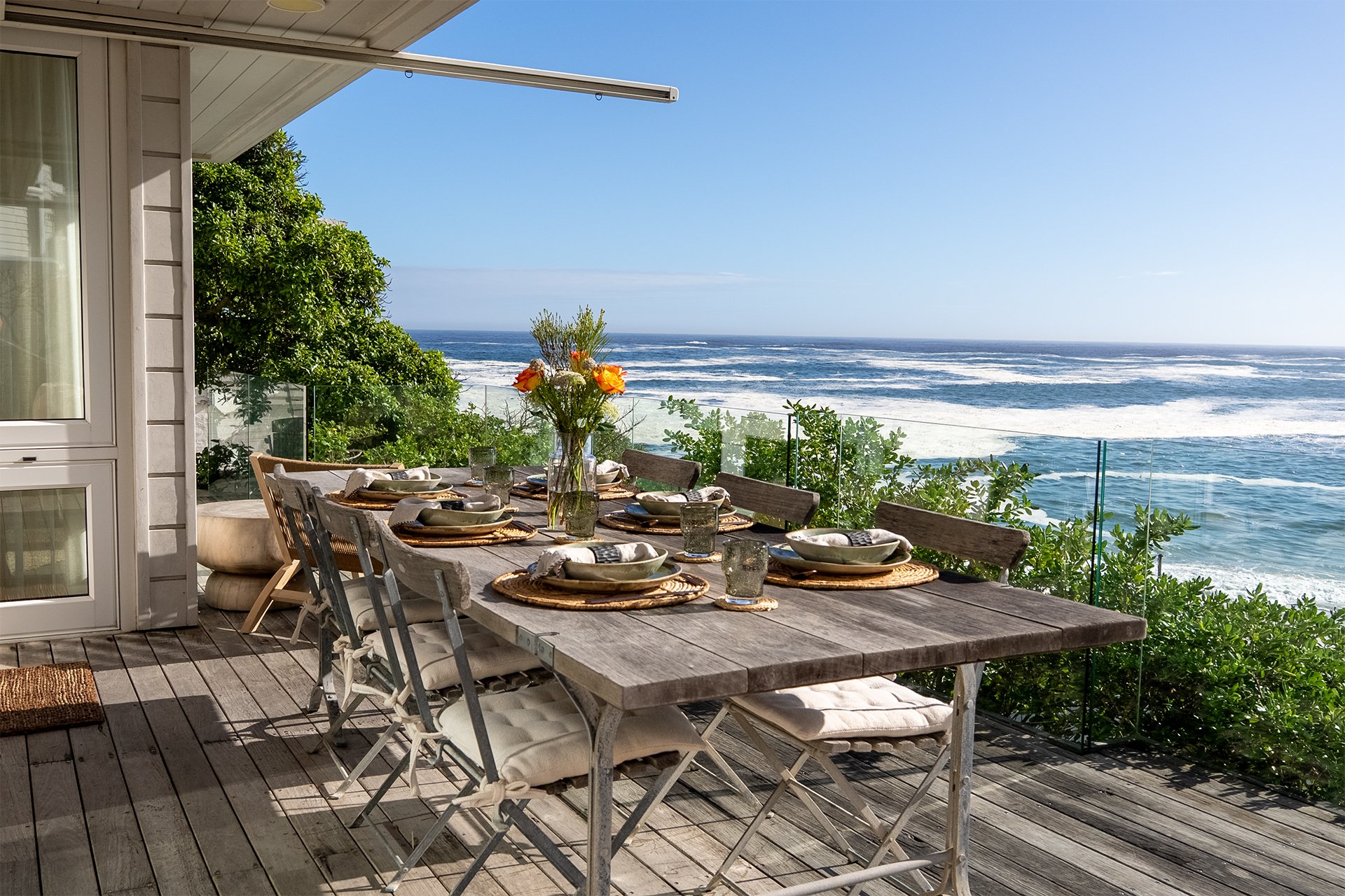 The open-plan kitchen, dining, living area and floor-to-ceiling windows open onto a spectacular glass-walled deck with gorgeous views. 