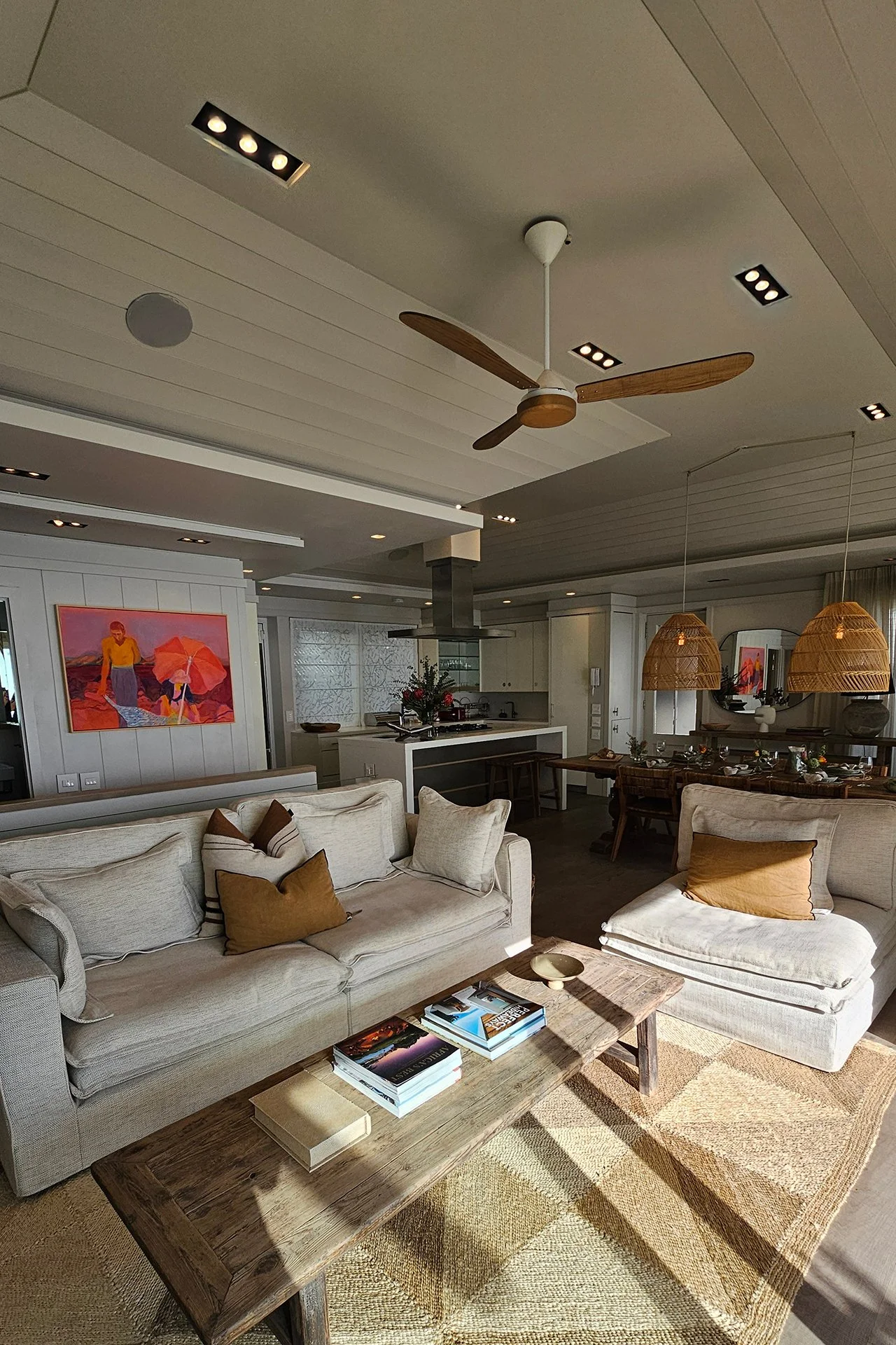 Open-plan space fusing kitchen, dining and living areas with dreamy views and access to beachfront deck through floor-to-ceiling windows.