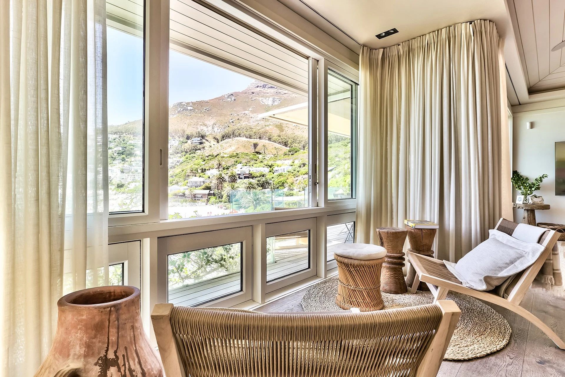 Open-plan space fusing kitchen, dining and living areas with dreamy views and access to beachfront deck through floor-to-ceiling windows. In the living room and dining area there’s a magnificent artisan wood dining table with space for eight guests, 