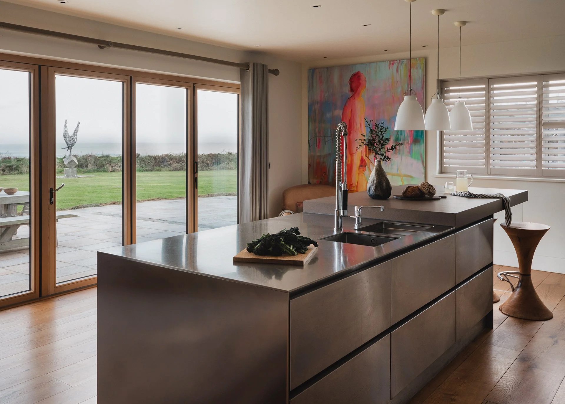 The kitchen has a stylish breakfast bar and utilises luxury appliances by Gaggenau and surfaces made from local stone.