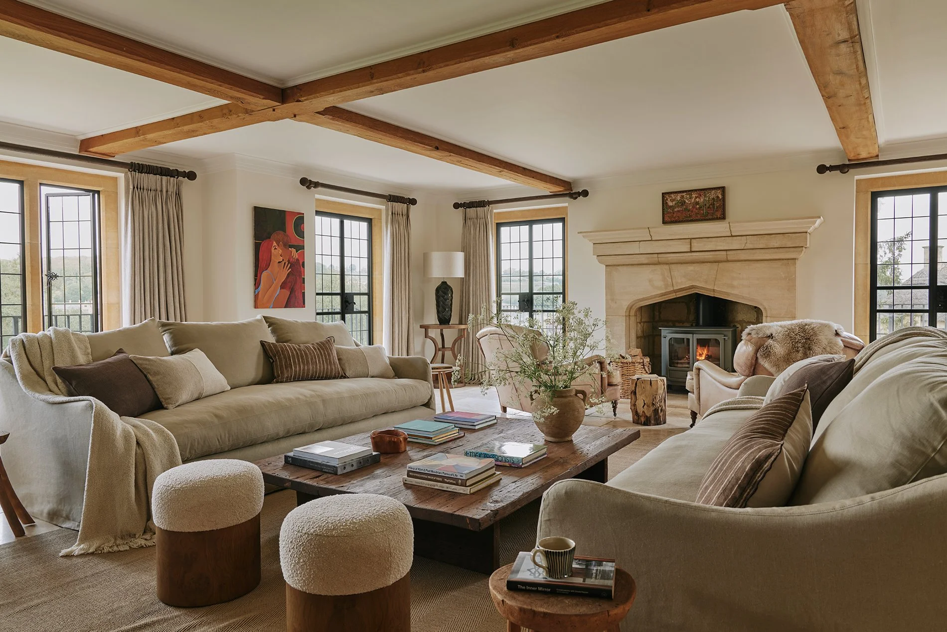 The living room is stylish and elegant, with a large woodburning stove, flagstone flooring, decadent rugs and two sumptuous sofas. Enquire now for a cosy stay in the much-loved Cotswolds countryside at Elkstones. 