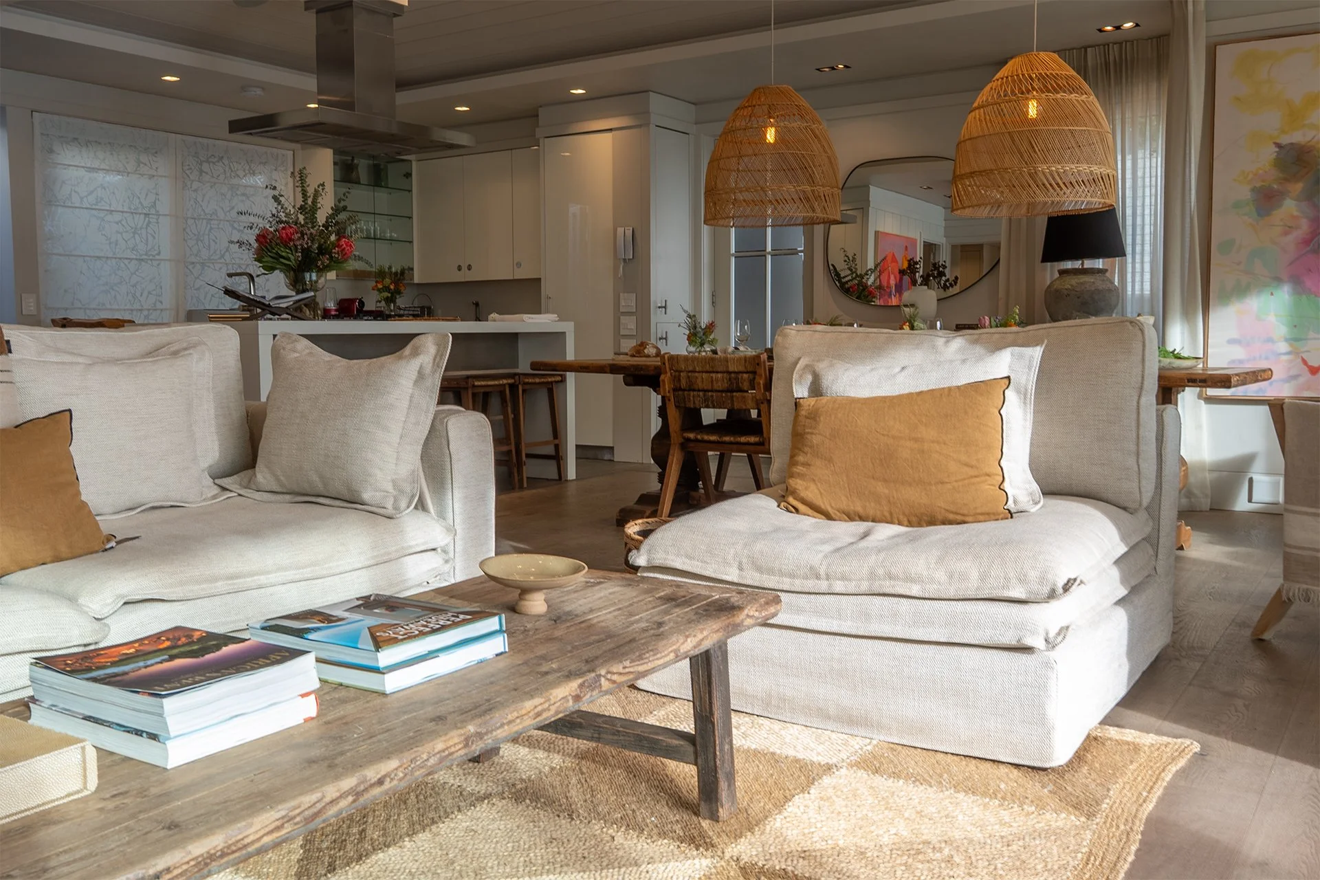 Open-plan space fusing kitchen, dining and living areas with dreamy views and access to beachfront deck through floor-to-ceiling windows. In the living room and dining area there’s a magnificent artisan wood dining table with space for eight guests, 