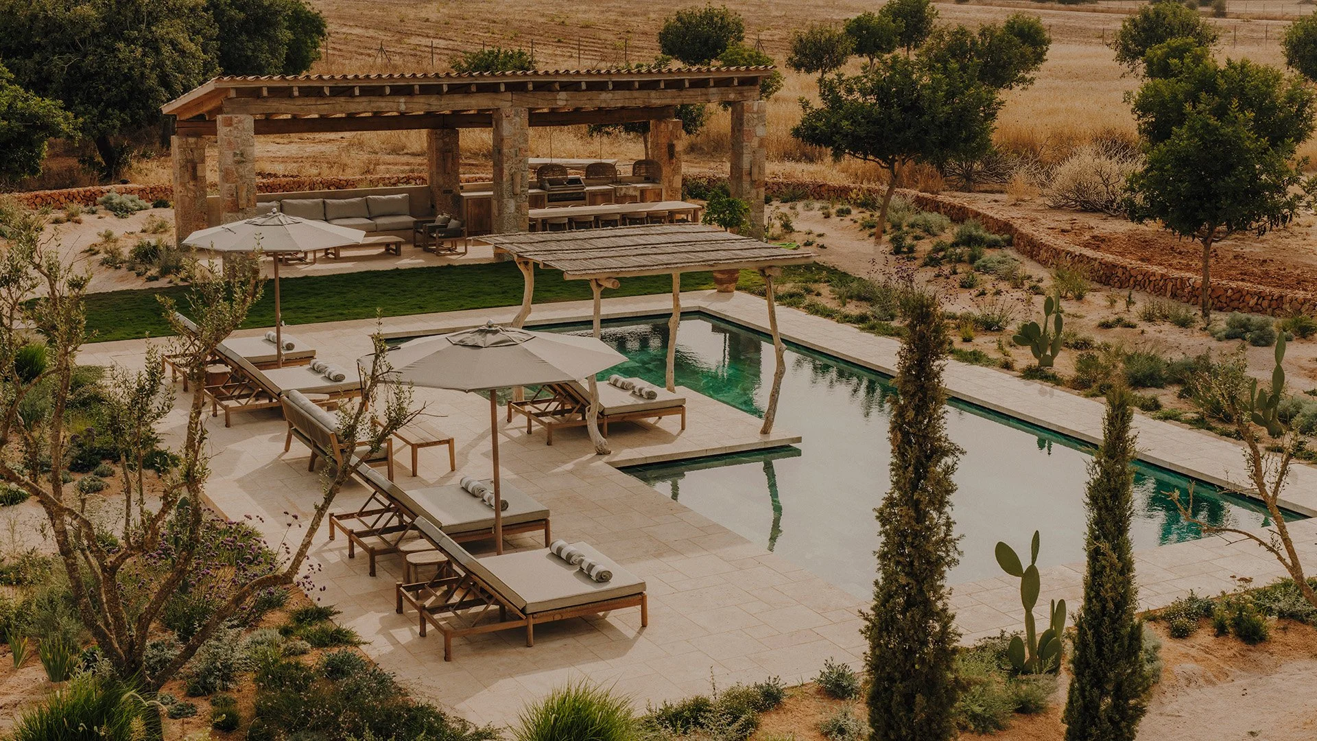 Outside, an expansive terrace frames the inviting swimming pool, while the outdoor kitchen and shaded lounge create an idyllic setting for long, leisurely lunches and relaxed evenings beneath the Mallorcan sky.