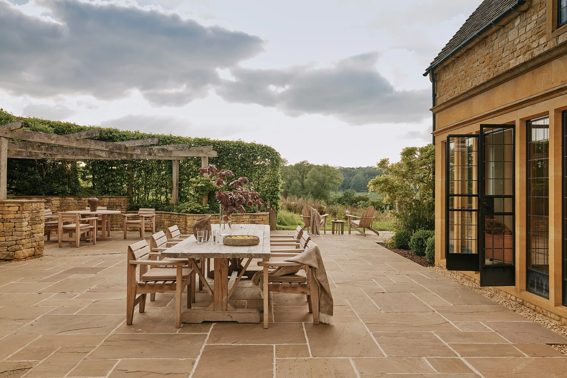 Large landscaped gardens feature a decorative ha-ha and sunny upper terrace. Another terrace adjacent to the kitchen with built-in seating, table and a BBQ is perfect for al fresco dining. Enquire now for a luxury stay at Elkstones, Cotswolds. 