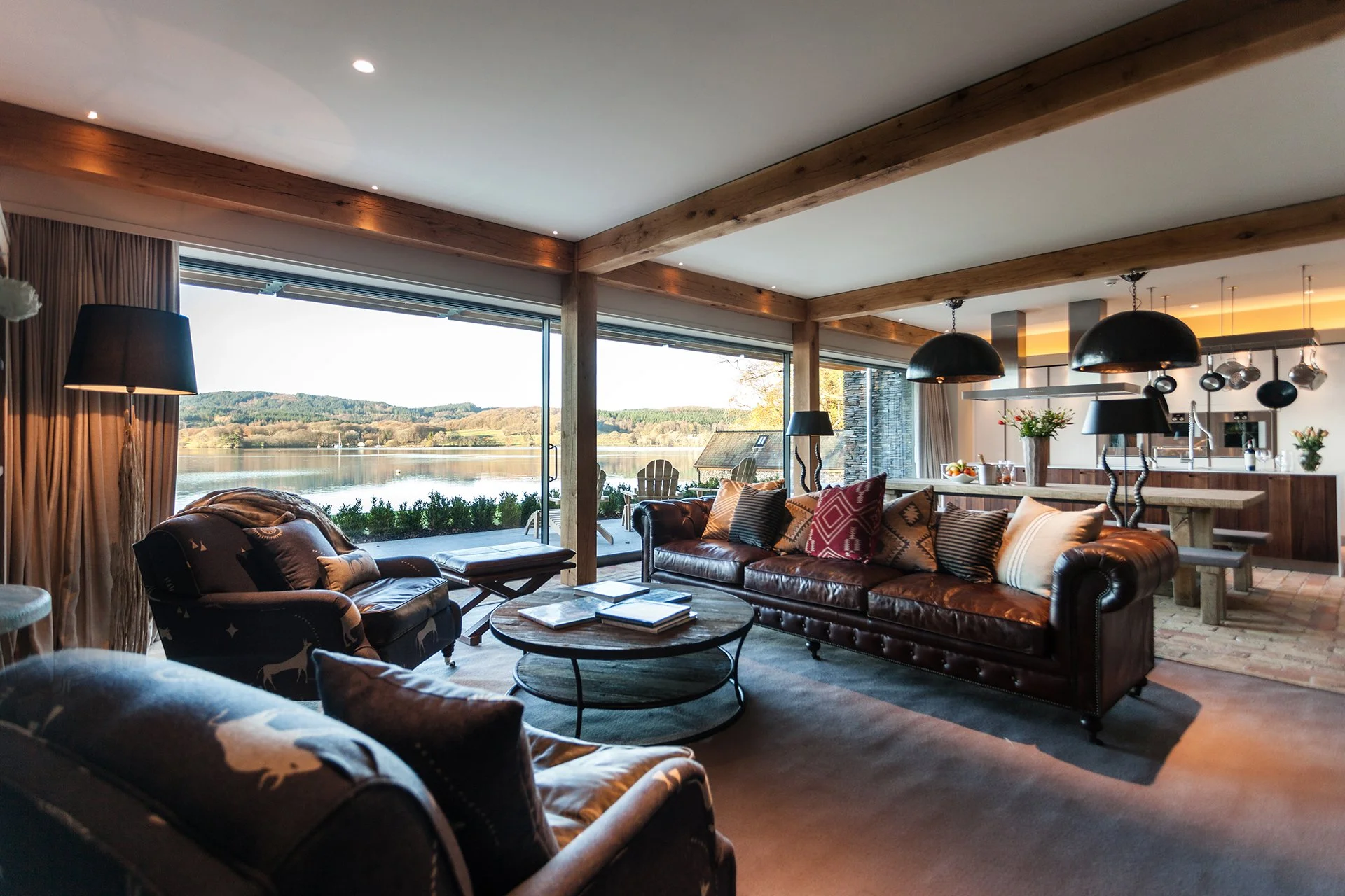 The main living room’s double-fronted windows open onto an acre of garden and the stylish kitchen boasts all the latest mod cons and furniture by the likes of Ralph Lauren, with a rustic green-oak dining table overlooking the lake.