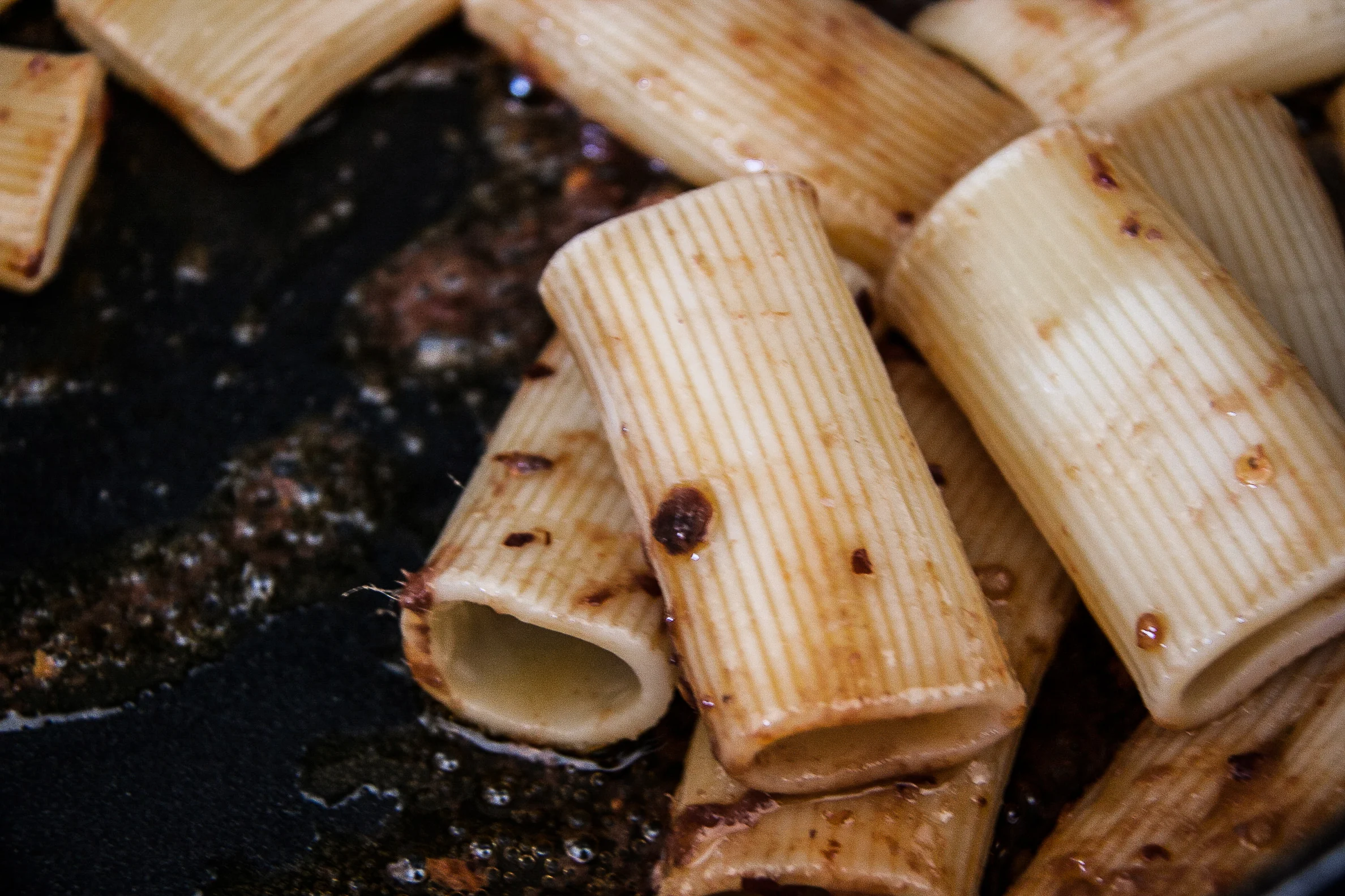 De anjovis en chillivlokjes blijven kleven aan de pasta, je vuur staat redelijk hoog.