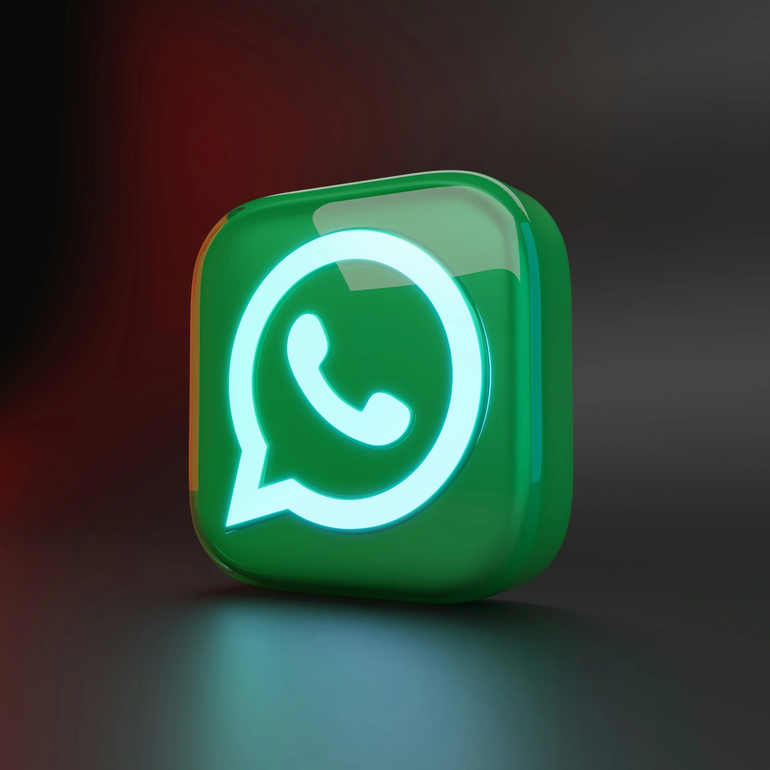 A neon sign shaped like a green speech bubble with a white phone receiver icon inside, illuminated against a dark background.