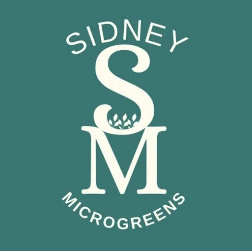 Logo for Sidney Microgreens with a large 'S' and 'M', with small leaves growing inside the 'S', on a teal background.
