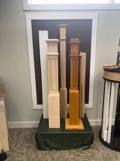Various wooden newel posts displayed indoors near a window.