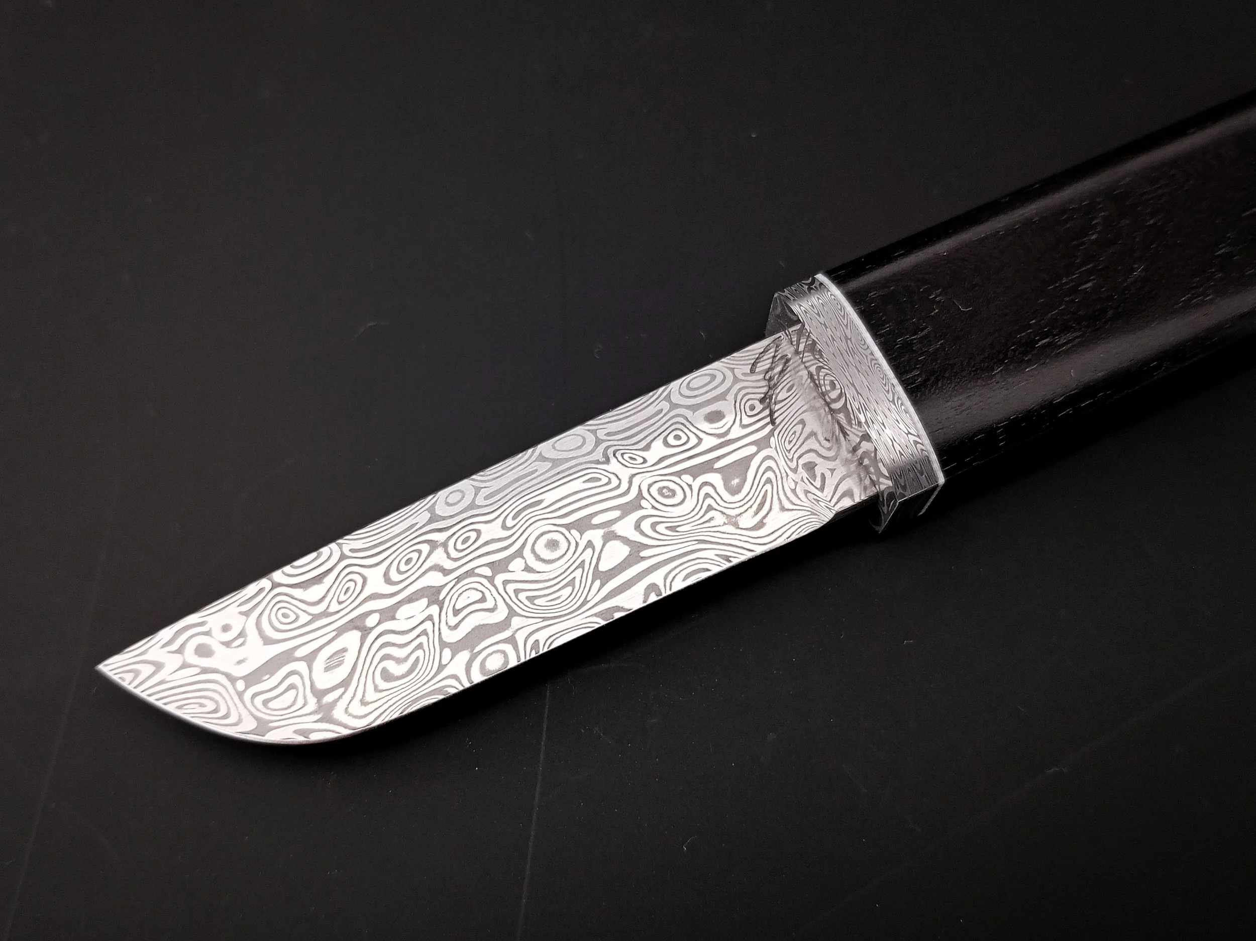 Damascus steel blade and a black handle.