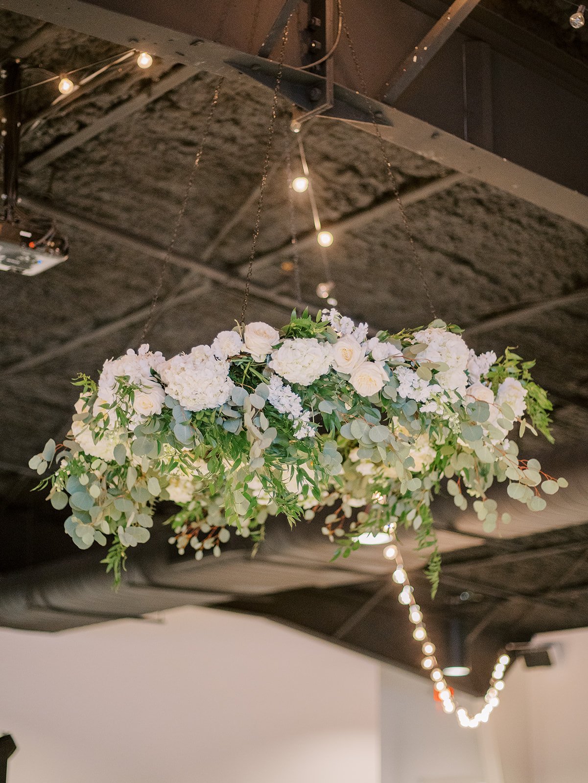 organic hanging floral installment with ivory flowers and greenery